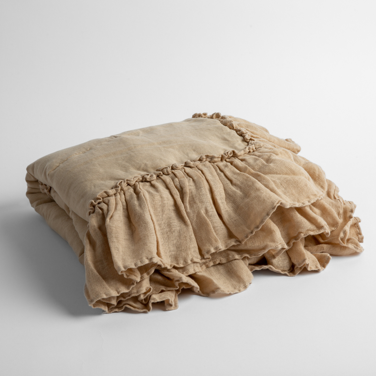 Honeycomb:   a folded linen with linen whisper ruffled blanket folded and positioned to show the ruffle detail against a white background and slightly overhead. 