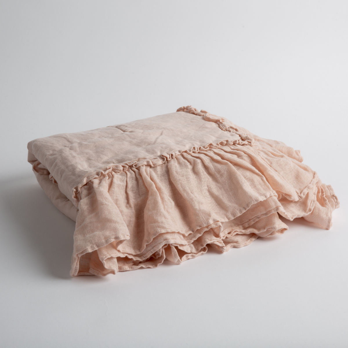 Pearl:  a folded linen with linen whisper ruffled blanket folded and positioned to show the ruffle detail against a white background and slightly overhead. 
