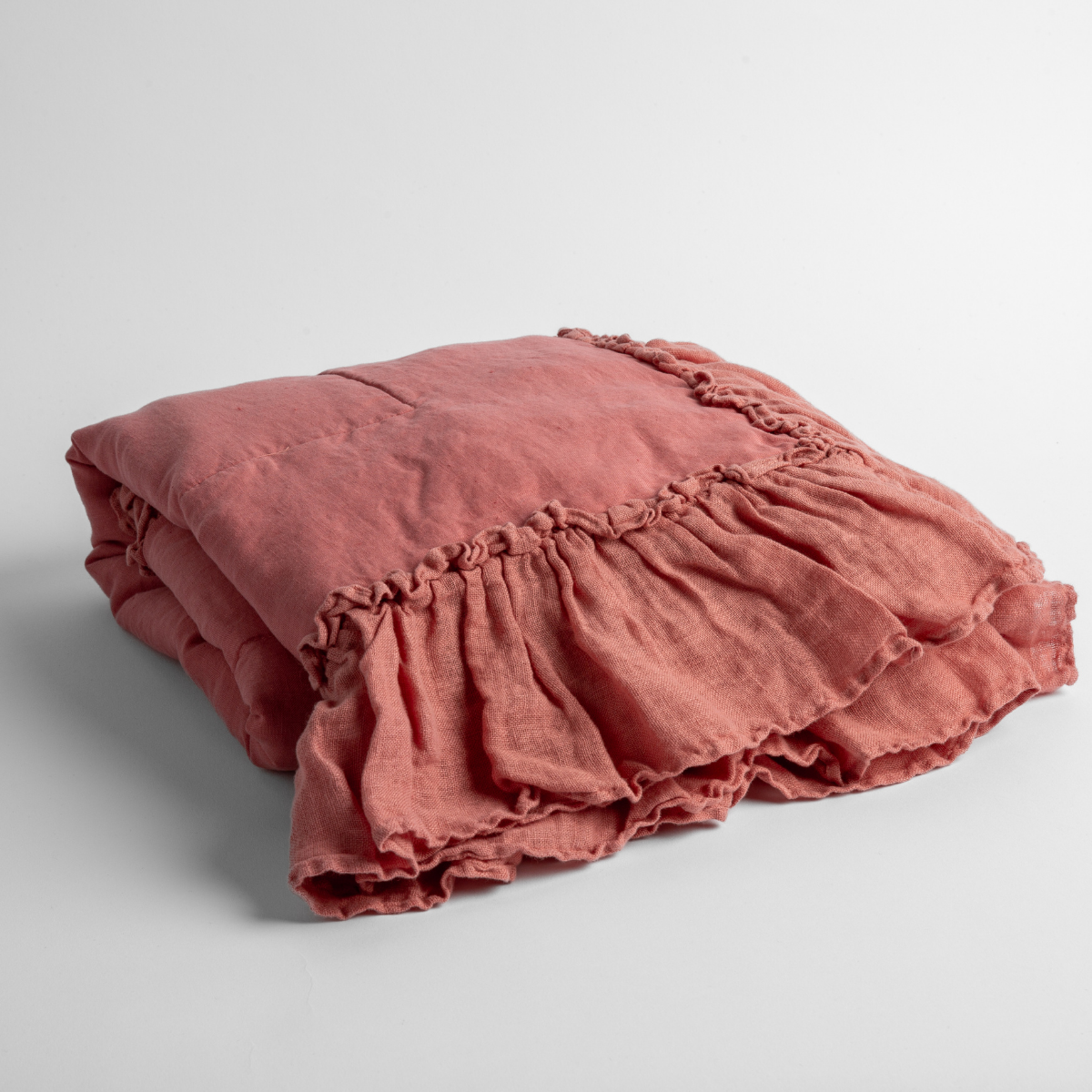 Poppy:  a folded linen with linen whisper ruffled blanket folded and positioned to show the ruffle detail against a white background and slightly overhead. 