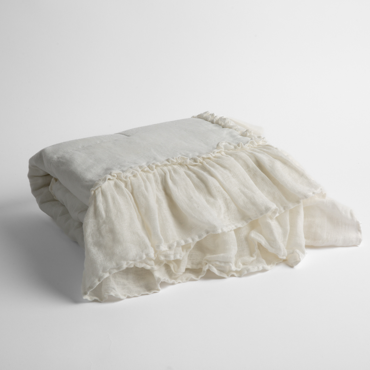 Winter White: a folded linen with linen whisper ruffled blanket folded and positioned to show the ruffle detail against a white background and slightly overhead. 
