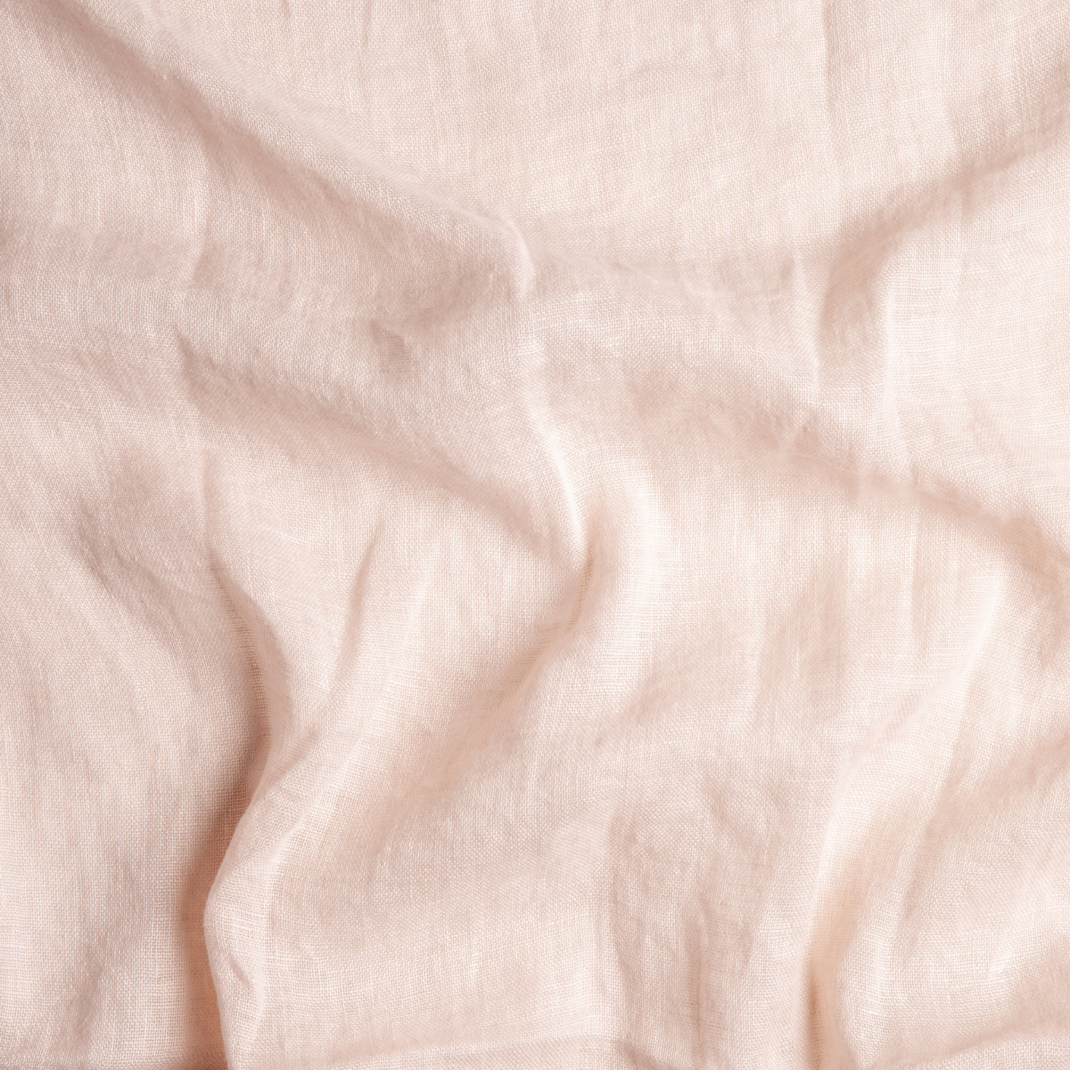 Pearl: A close up of linen whisper fabric in pearl, a nude-like, soft rose pink tone.