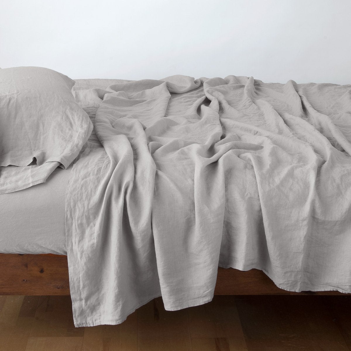 Fog: sleeping pillow with matching rumpled sheeting - side view.