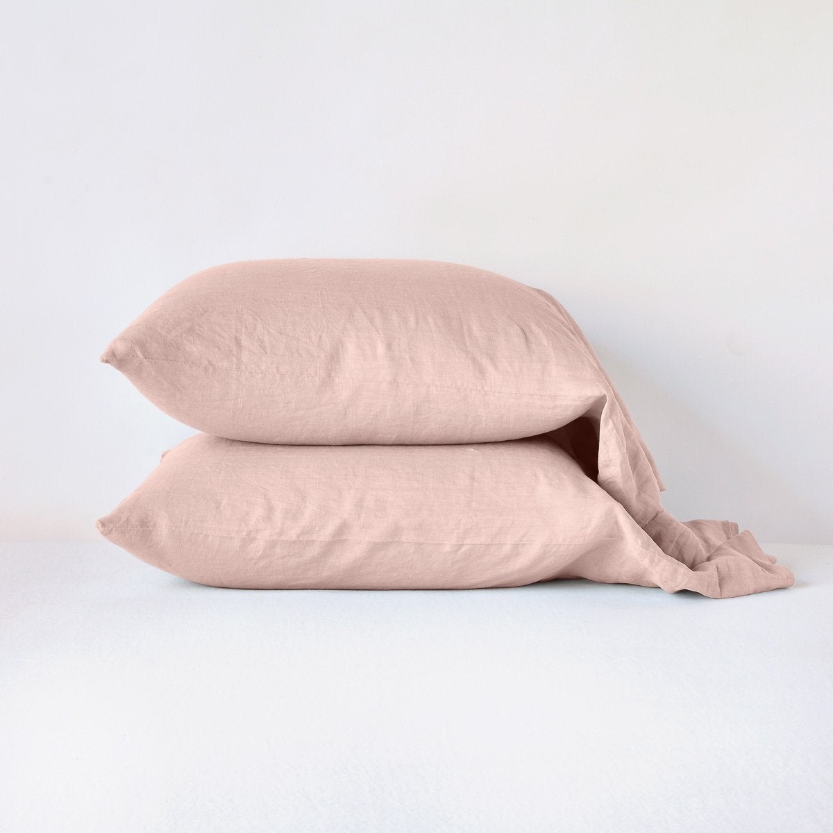 Rouge: Two sleeping pillows neatly stacked against a white background - side view.