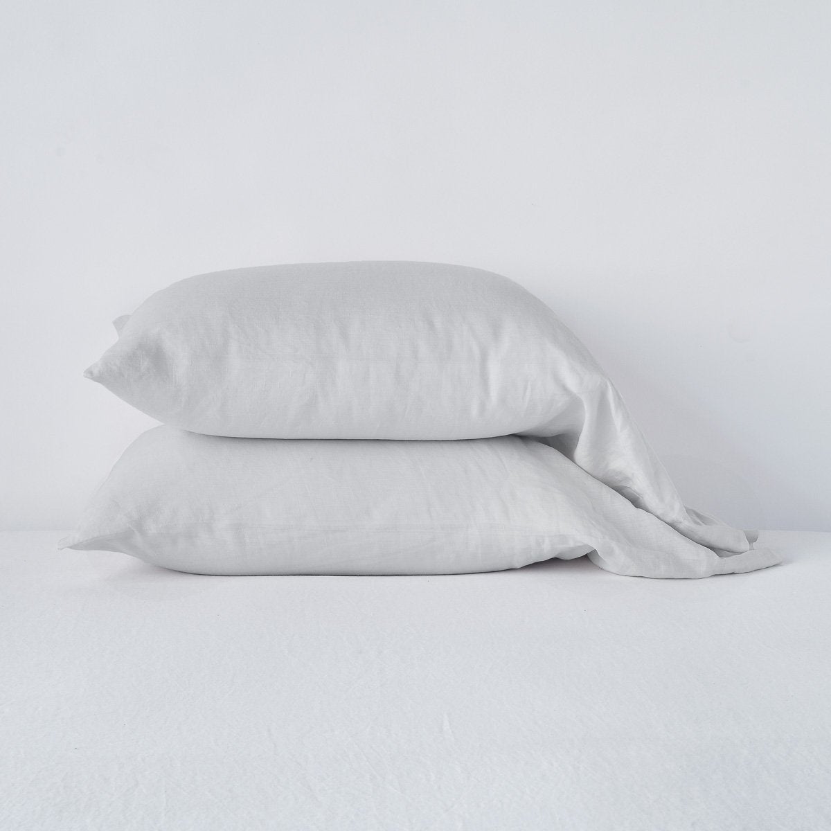 Sterling: Two sleeping pillows neatly stacked against a white background - side view.