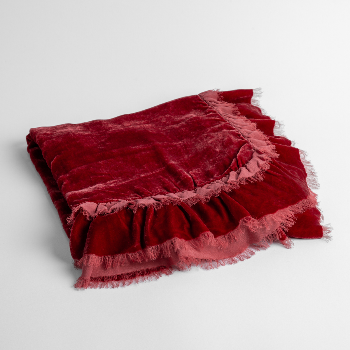 Poppy:  an overhead shot of a folded silk velvet baby blanket with a raw-edged eyelash ruffle detail.