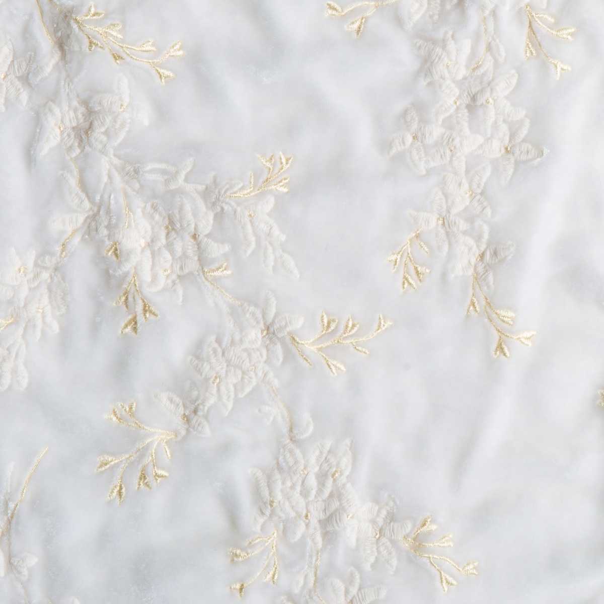 White: A close up of embroidered silk velvet fabric in classic white.