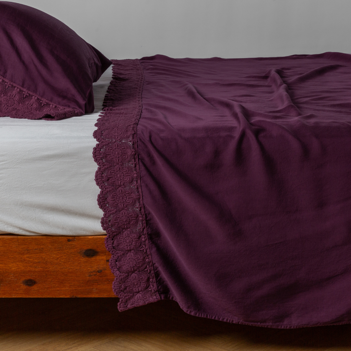 matching cotton lace trimmed flat sheet and pillowcase shown with simple white sheet - side view.