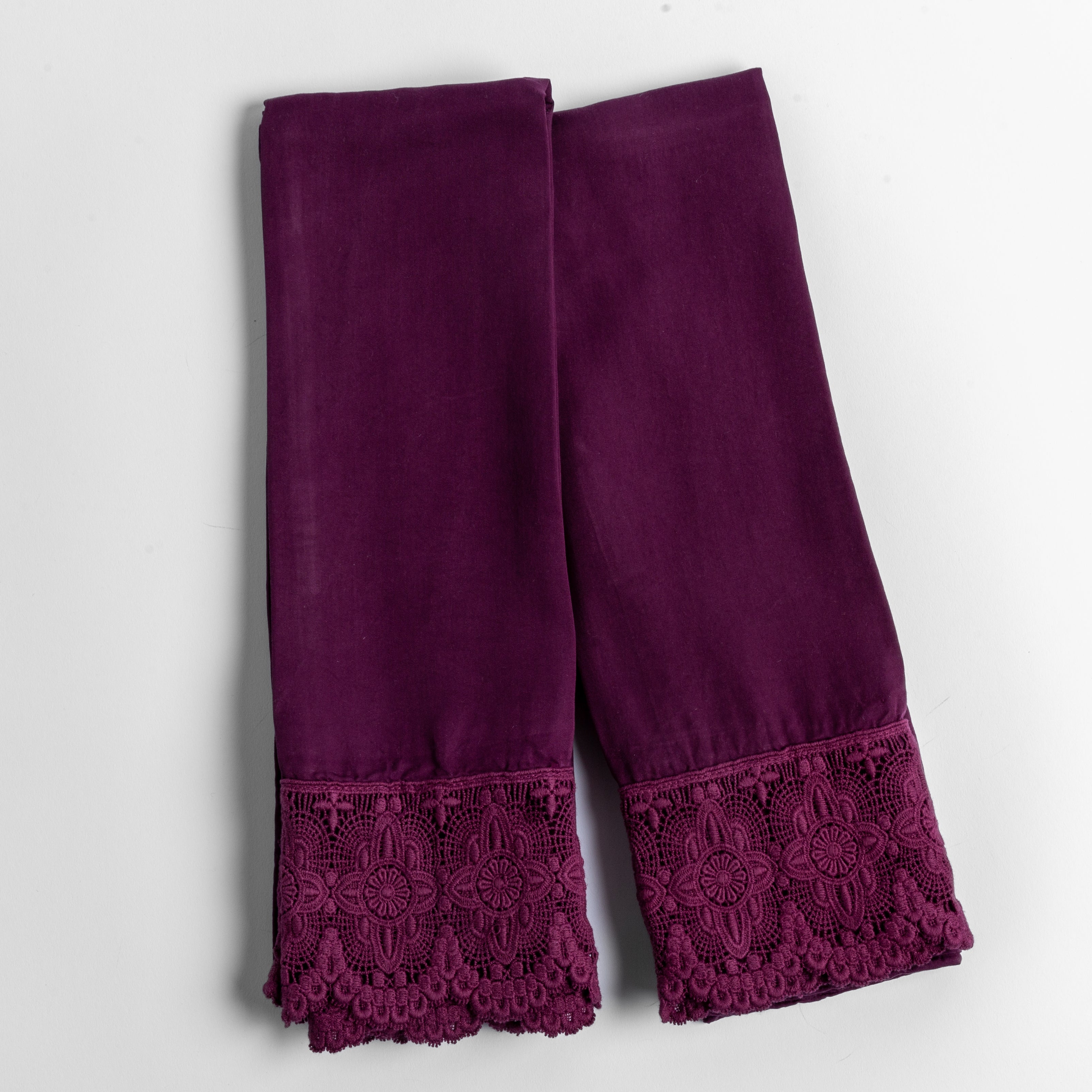 cotton lace trimmed tencel pillowcases folded and shot from overhead against a white background