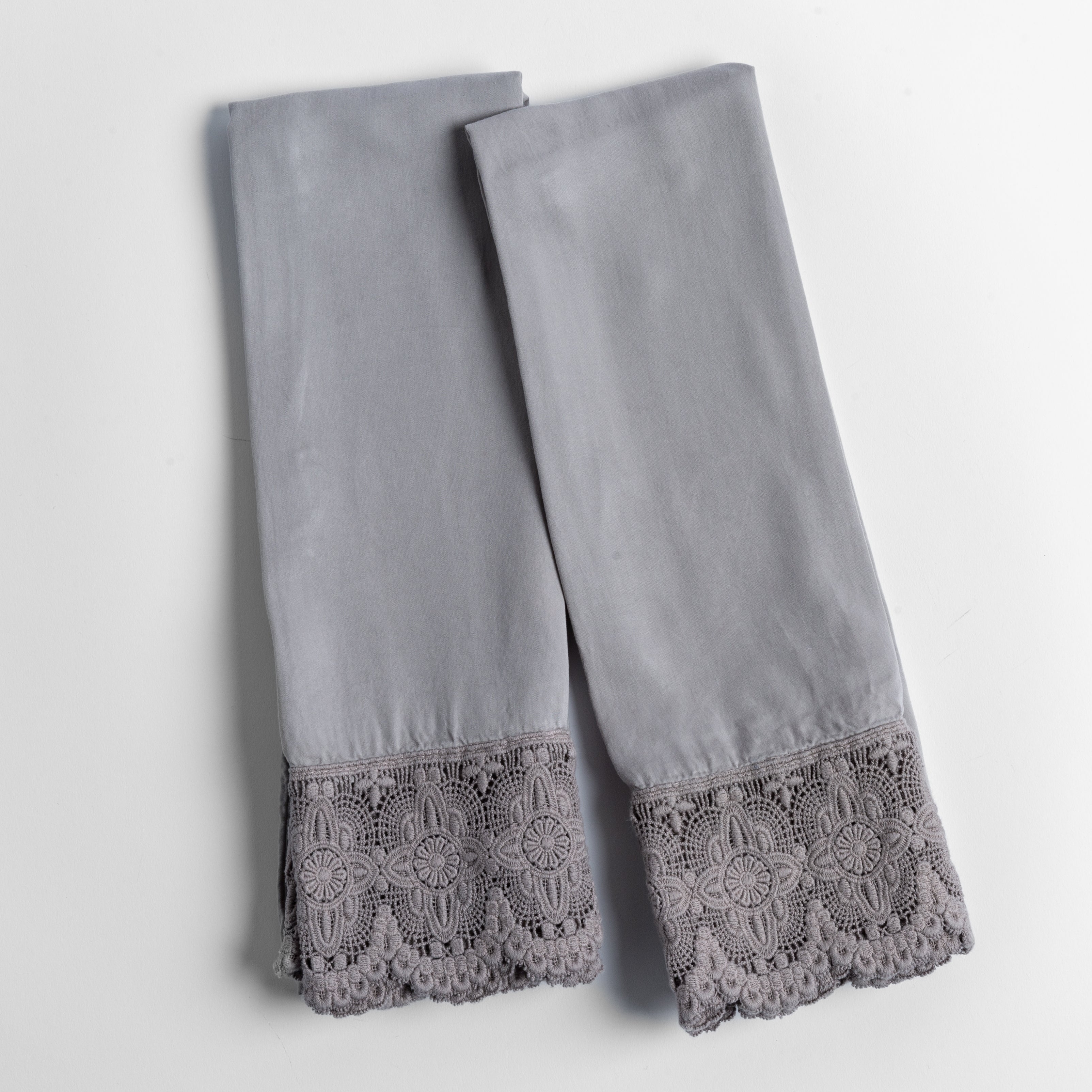 cotton lace trimmed tencel pillowcases folded and shot from overhead against a white background