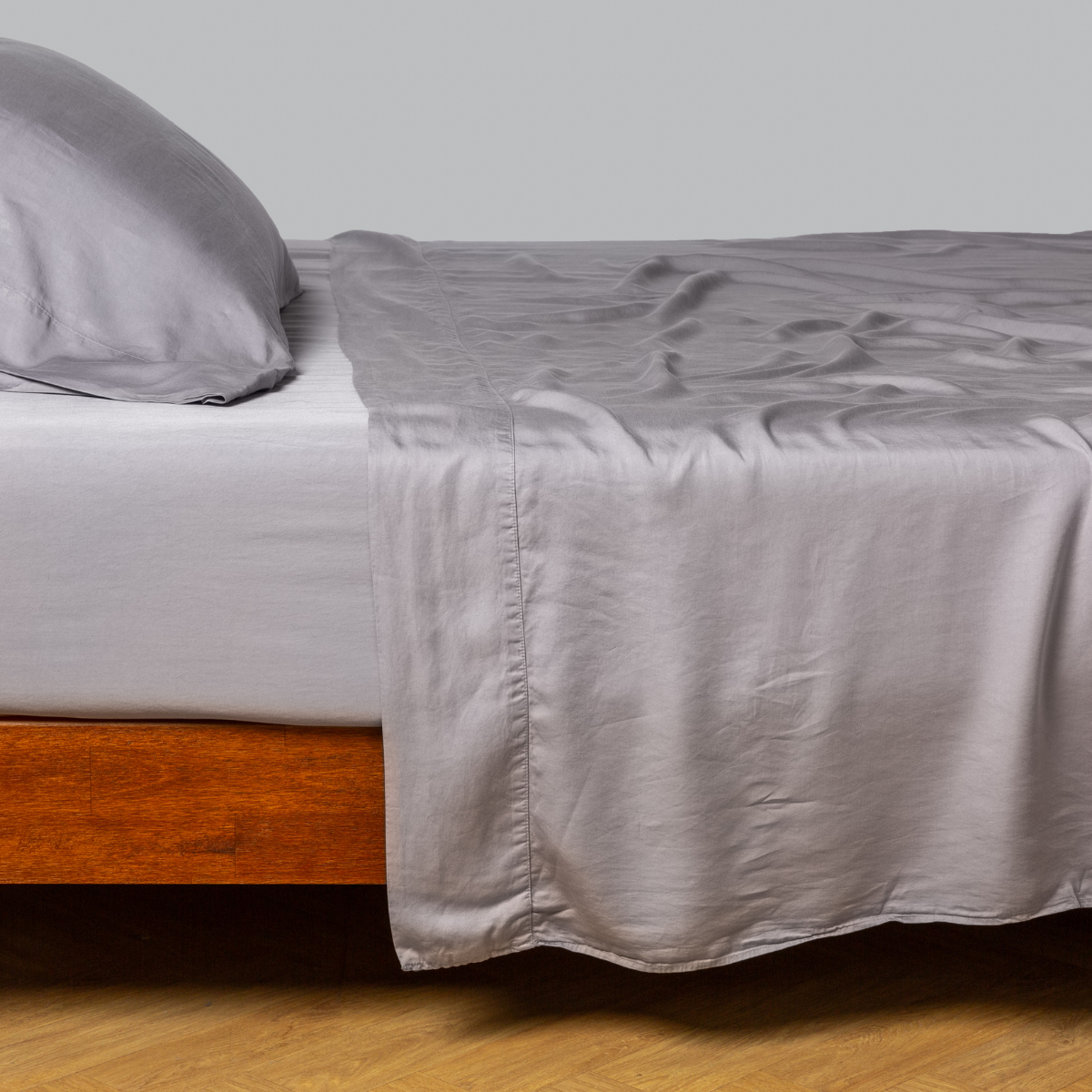 Tencel™ flat sheet with matching fitted sheet and sleep pillow from the madera luxe collection - side view. 