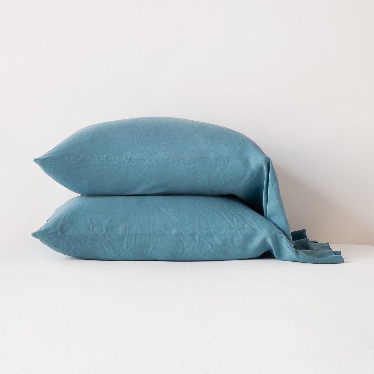 Cenote: sleeping pillows stacked neatly against a white backdrop - side view.