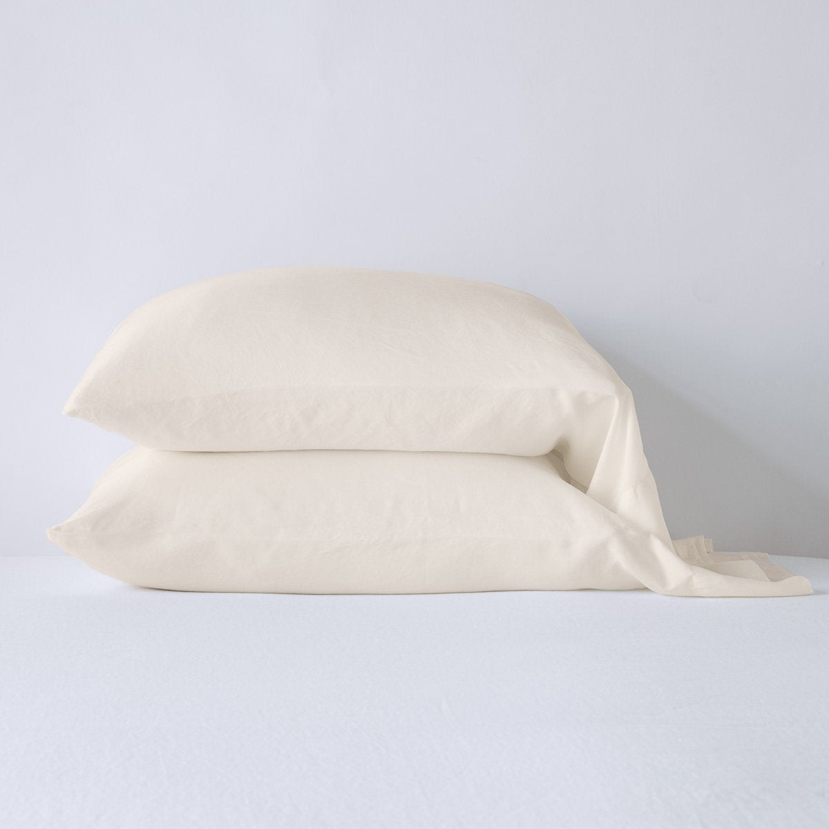 Parchment: sleeping pillows stacked neatly against a white backdrop - side view.