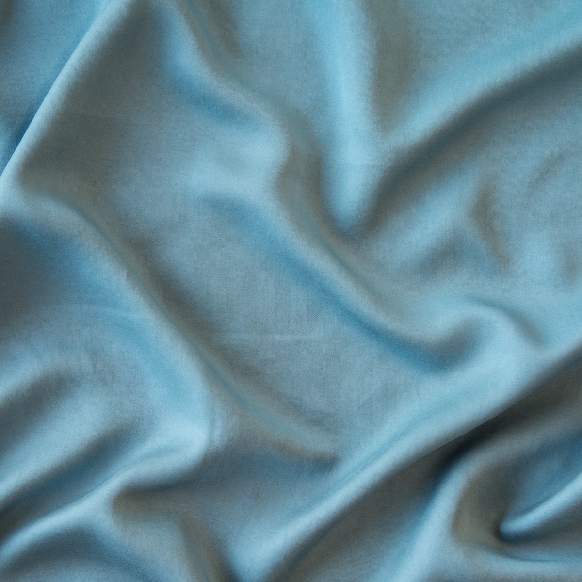 Cenote: A close up of Tencel™ in cenote, a vibrant, ocean-inspired blue-green. 