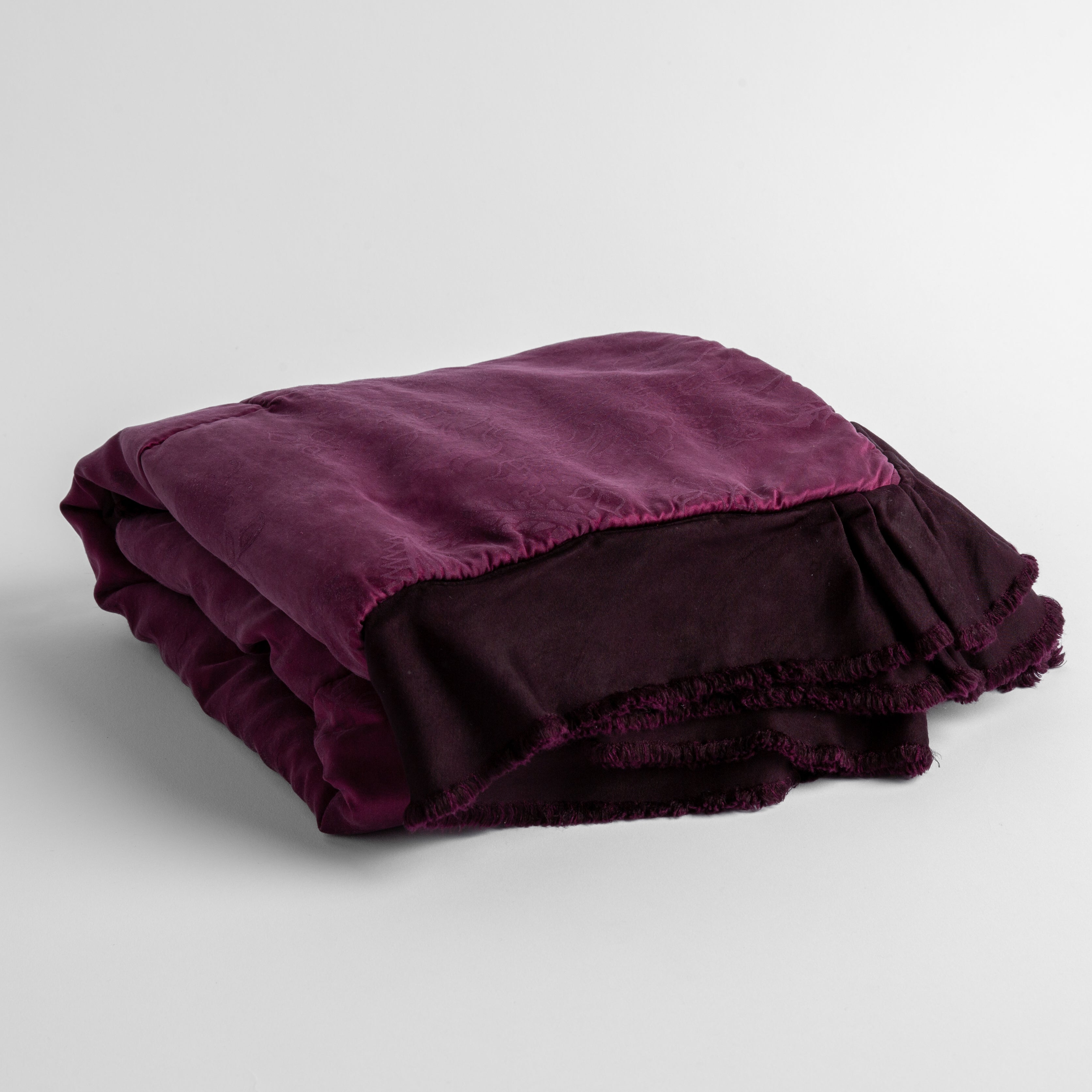 Fig: a silk and tencel™ jacquard baby blanket folded and shot against a white background with the ruffled trim situated to be visible