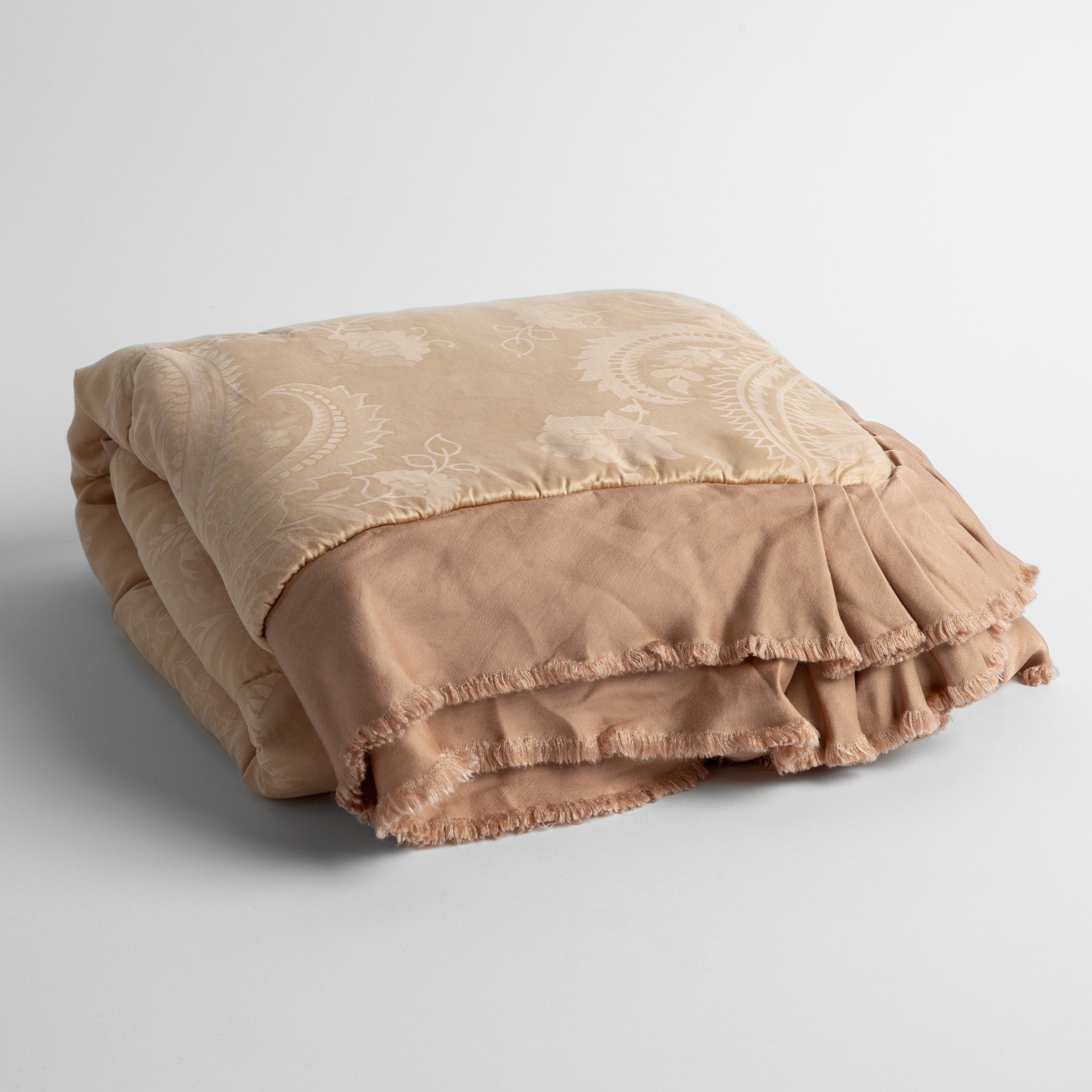 Rouge: a silk and tencel™ jacquard baby blanket folded and shot against a white background with the ruffled trim situated to be visible
