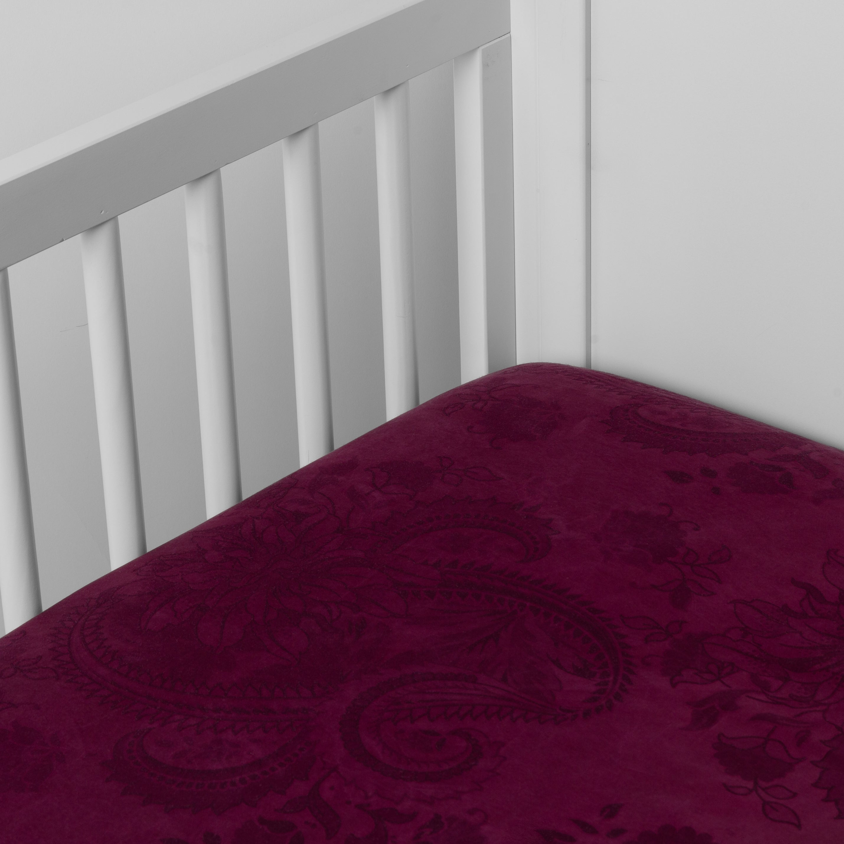 Fig: a silk and tencel™ crib sheet shown slightly overhread and shot into the corner of a white crib. 