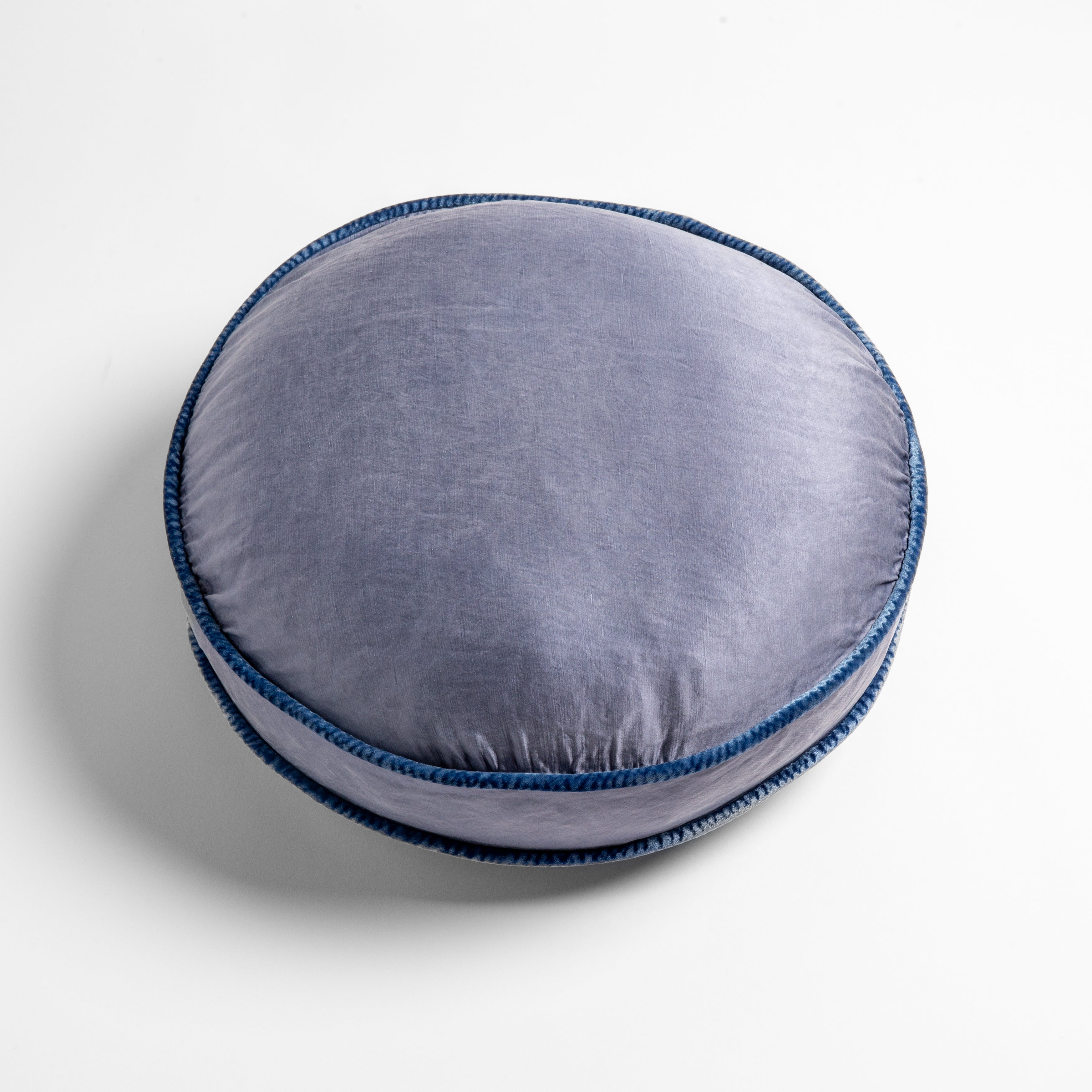 Tahoe Blue: 18" round charmeuse pillow with silk velvet trim at gusset shot from overhead on a white background