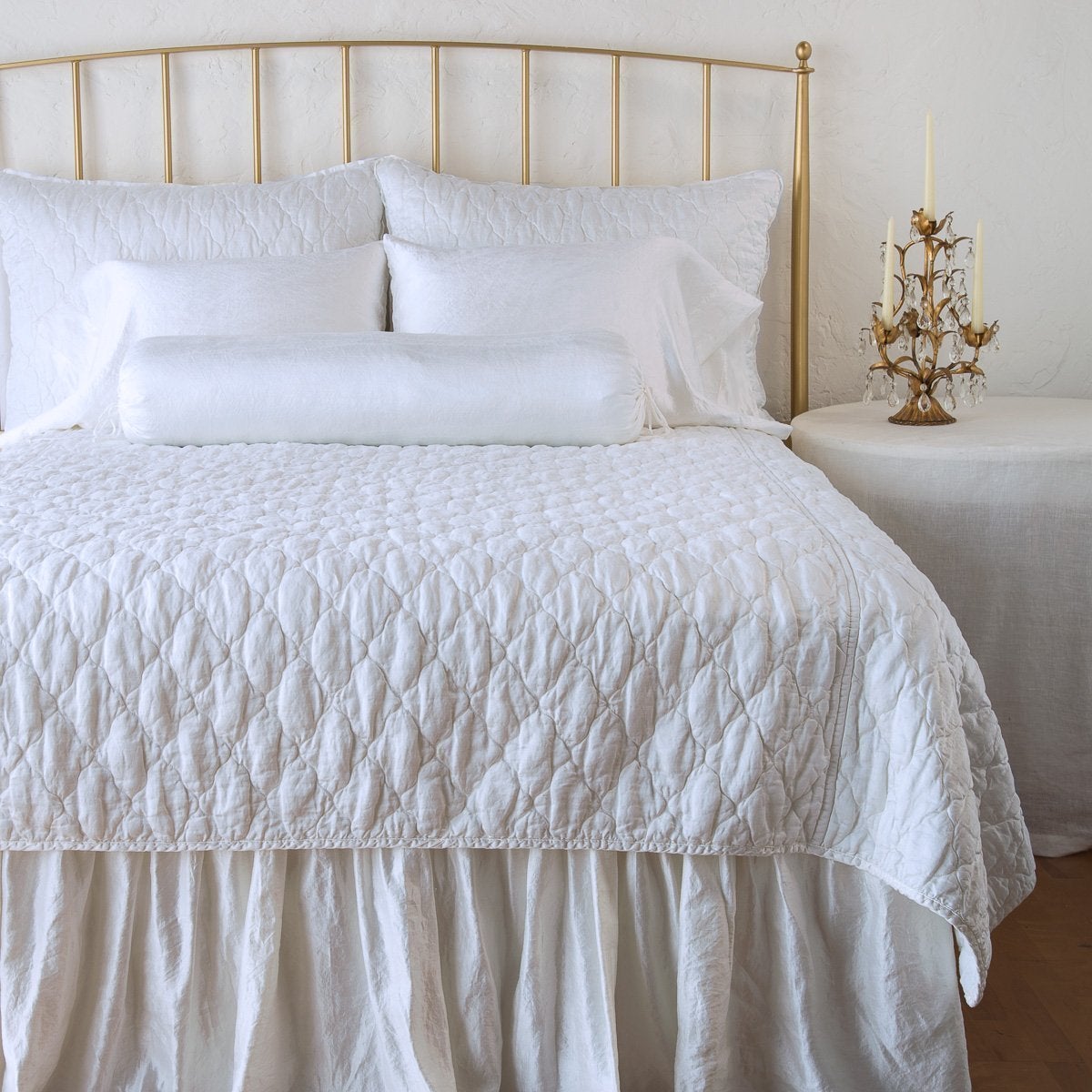 : Paloma sleeping pillows on a monochromatic, all-charmeuse bed - white, end of bed view.
