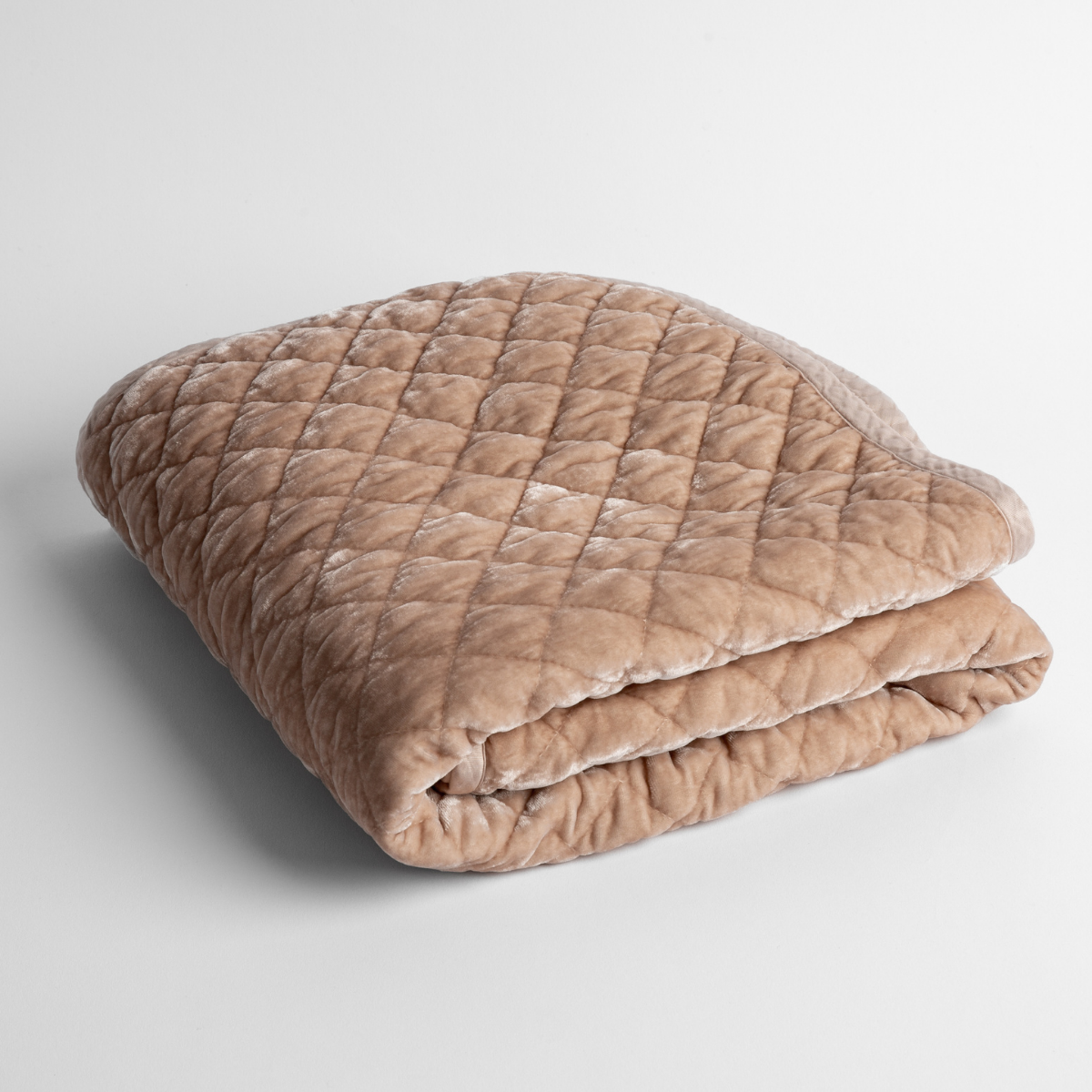 Pearl:   a folded quilted silk velvet baby blanket shown from overhead to showcase quilting  pattern and texture. 