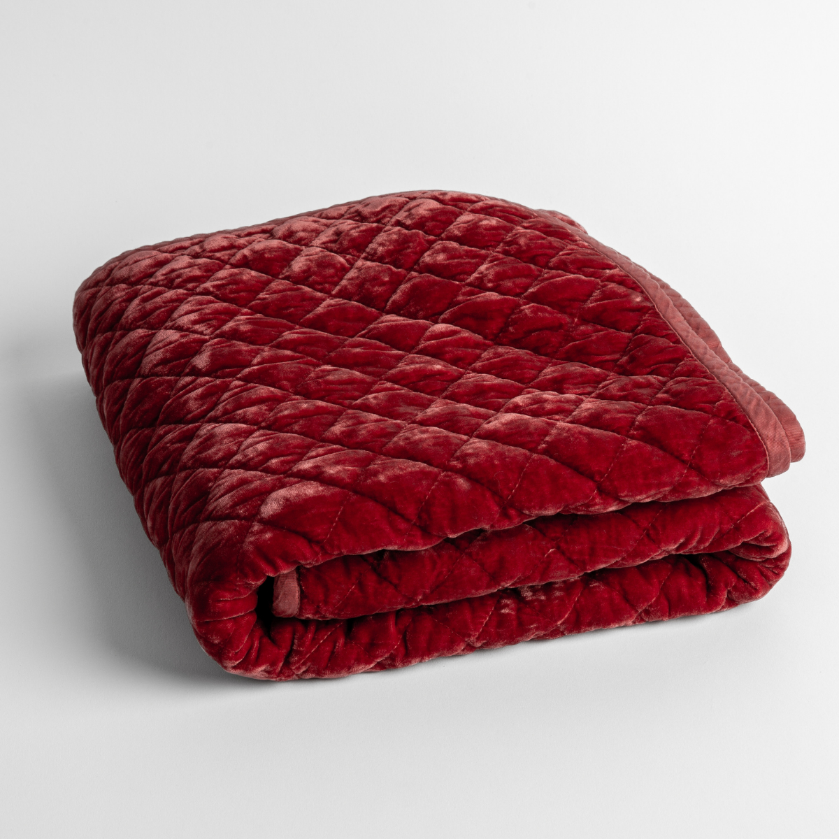 Poppy:   a folded quilted silk velvet baby blanket shown from overhead to showcase quilting  pattern and texture. 