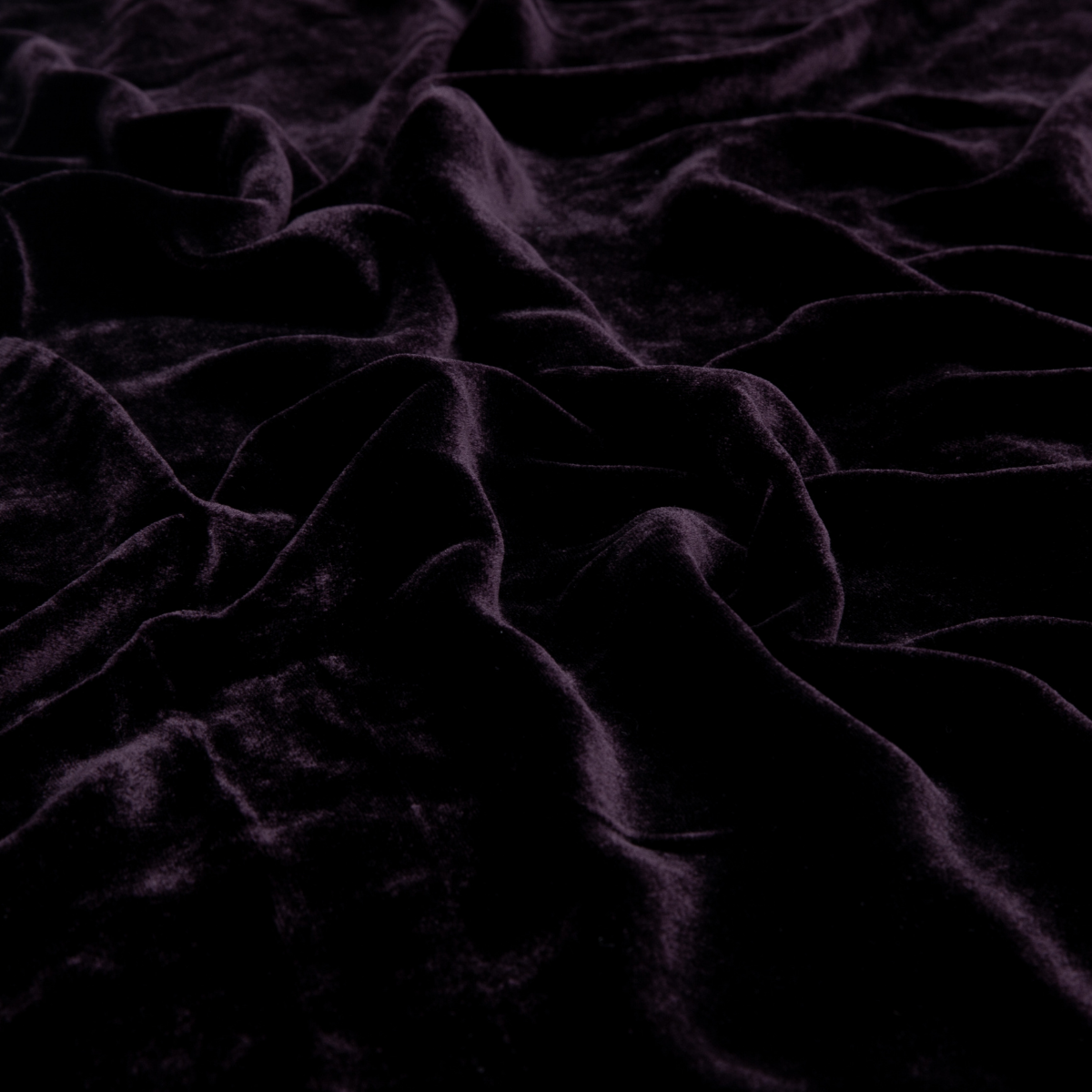 Fig: A close up of silk velvet fabric in fig, a richly saturated purple-garnet.