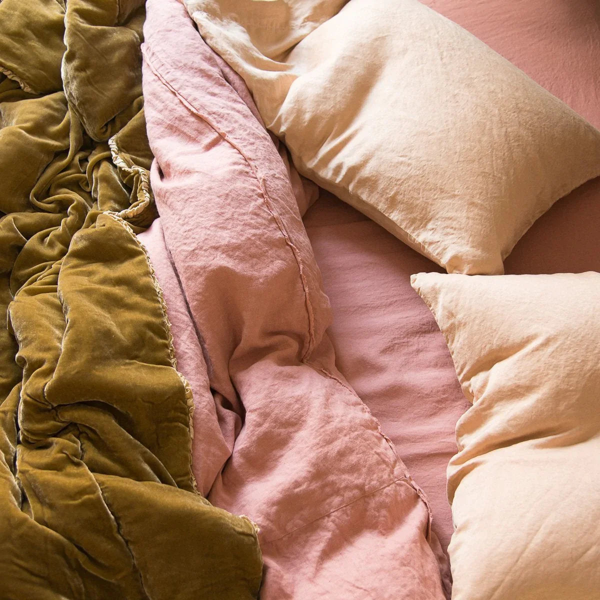 [allvariants]: Austin duvet cover shown rumpled from an overhead angle with silk velvet and silk charmeuse in pink and gold tones.