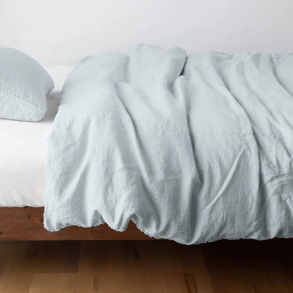 Cloud: Midweight linen duvet cover in cloud on a bed, side view.