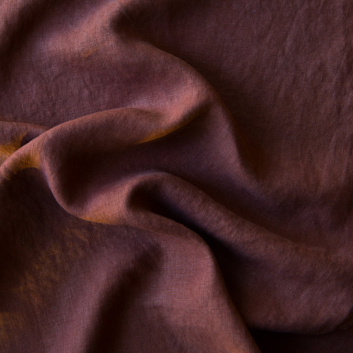 Mahogany: A close up of midweight linen in mahogany, a deep, earthen, reddish brown. 