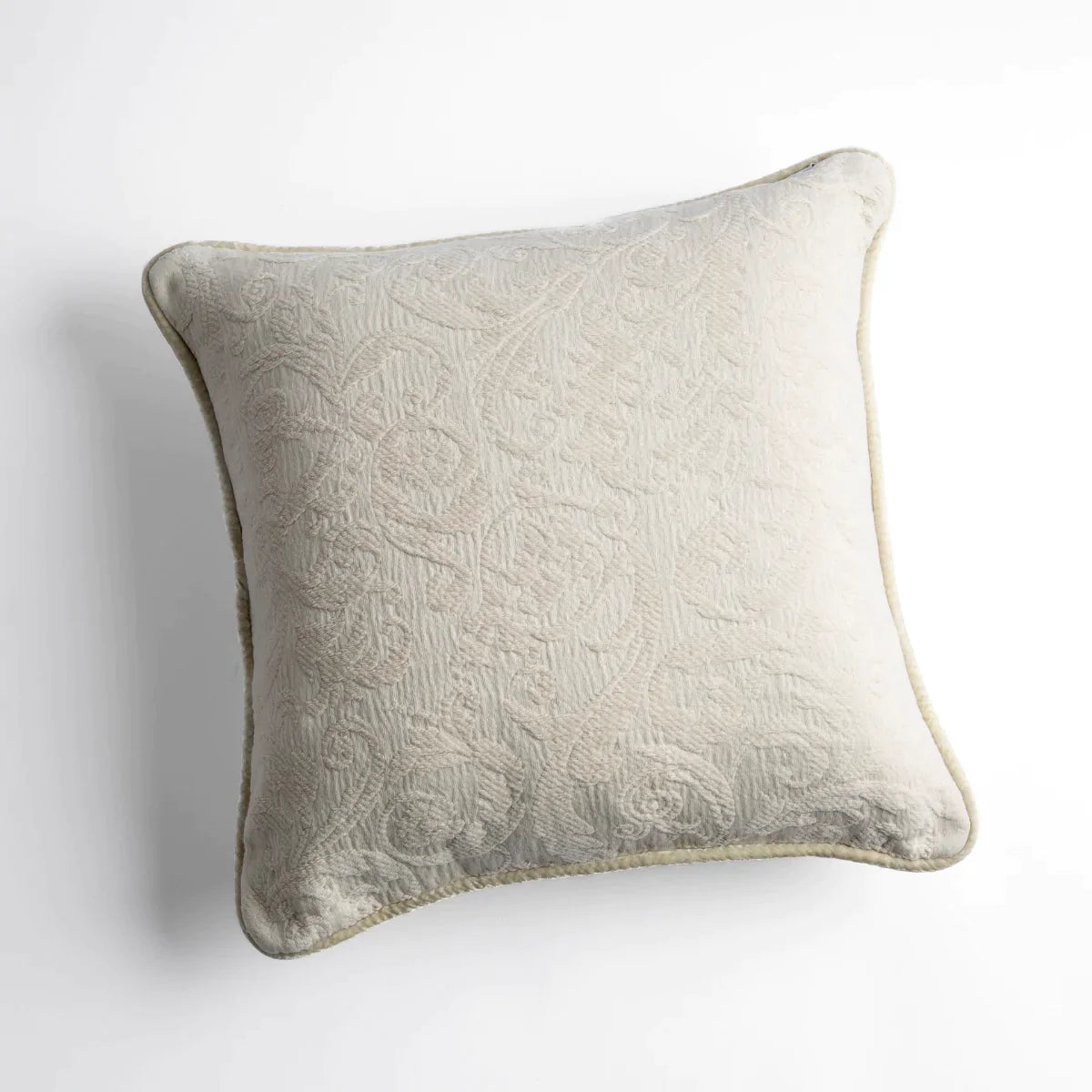 Parchment: Organic cotton damask square pillow with silk velvet trim on white background — overhead angle.