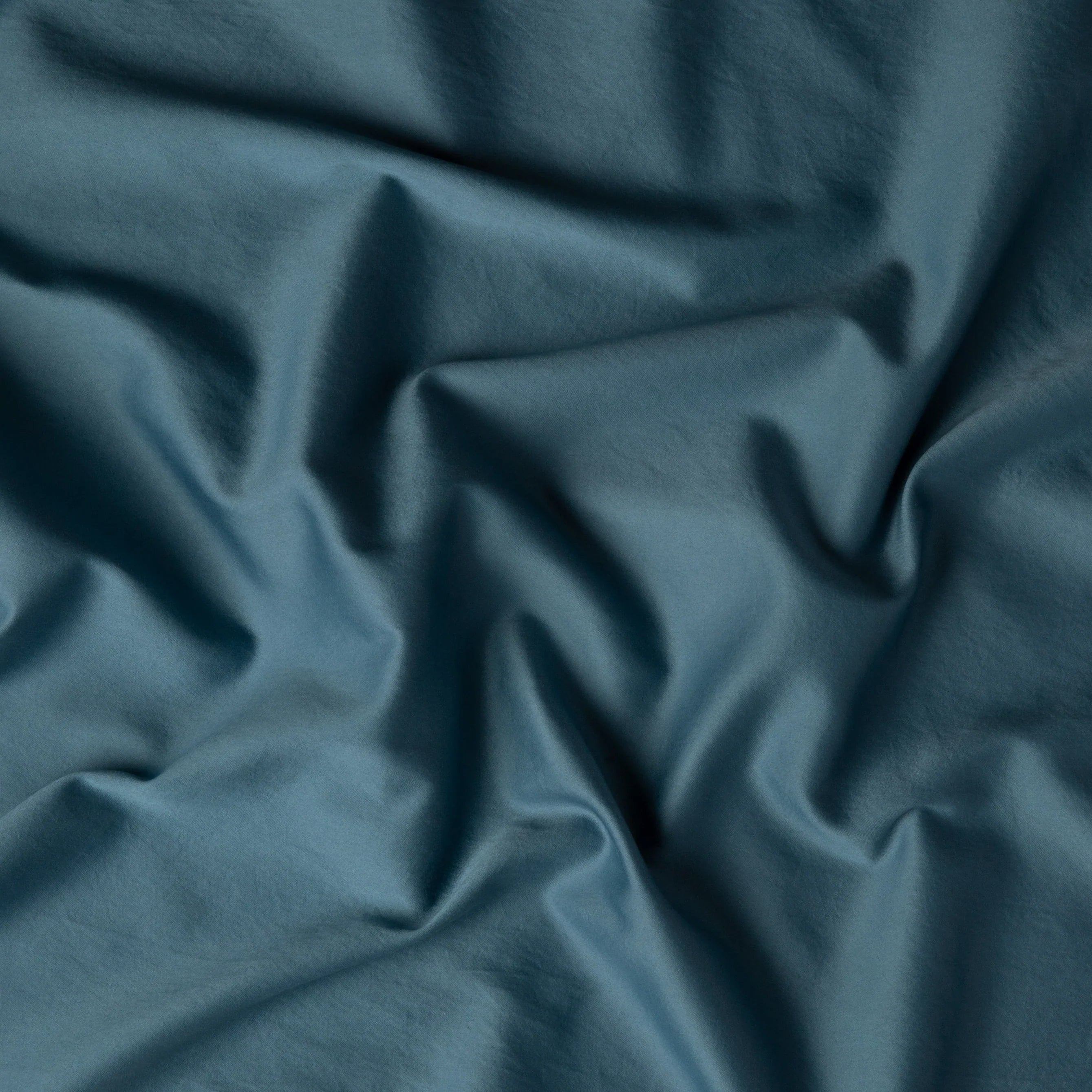 Cenote: A close up of cotton sateen fabric in cenote, a vibrant, ocean-inspired blue-green. 