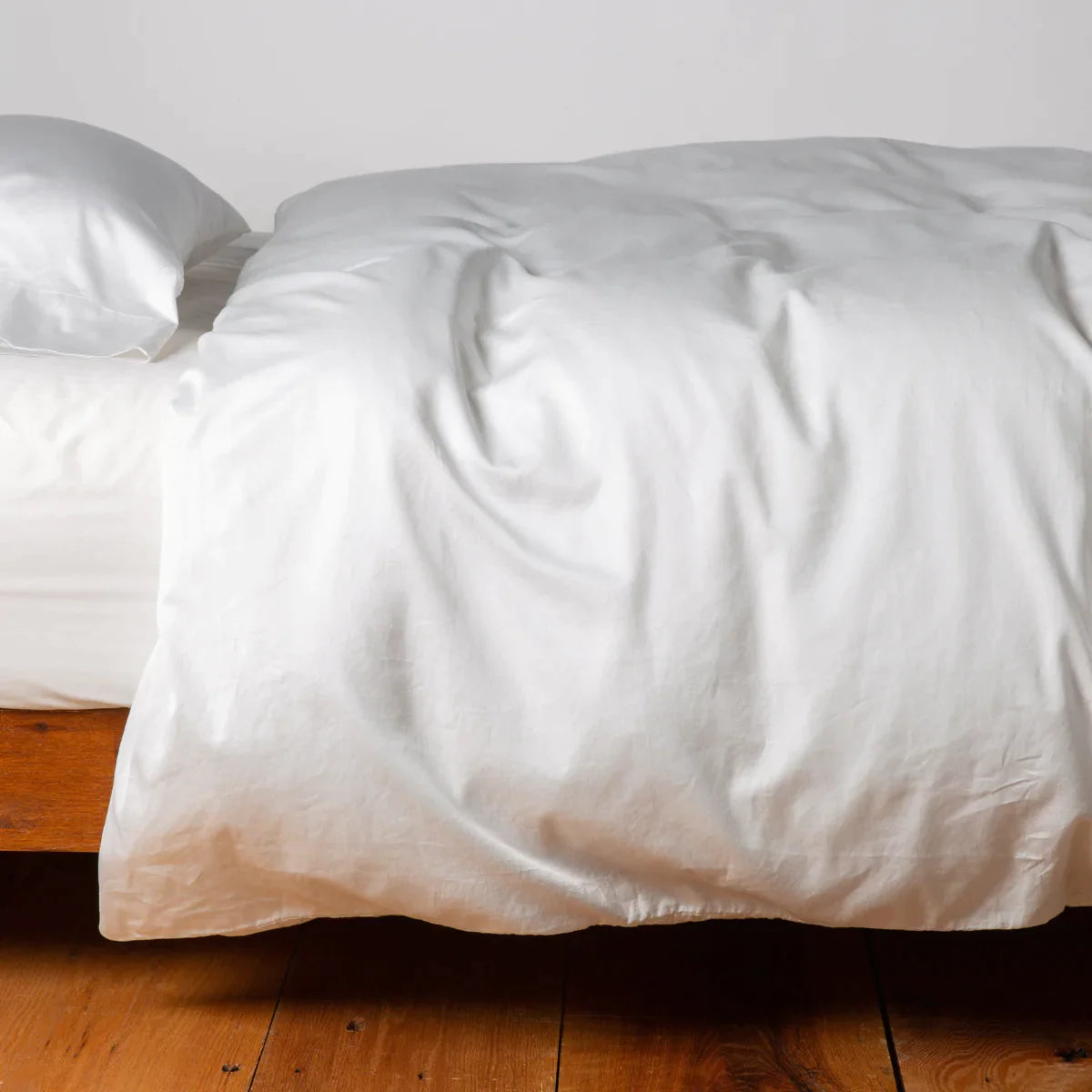 Winter White: duvet cover and matching sleeping pillow on white sheeting - side view.