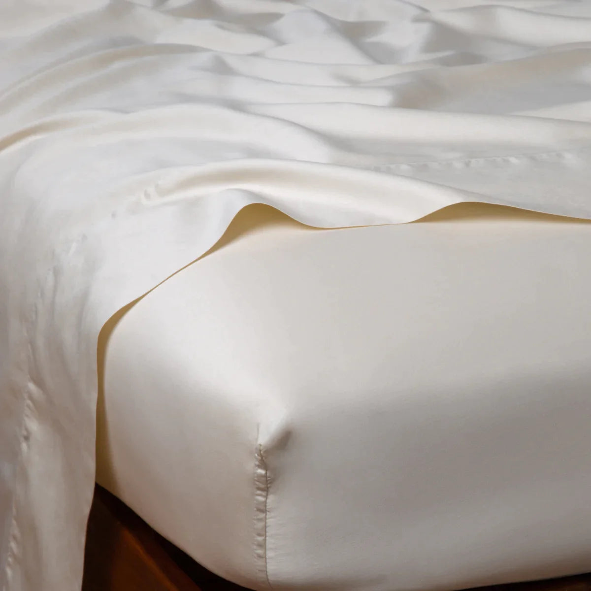 Parchment: Cotton sateen fitted sheet shown from the top corner, highlighting the shine of the fabric.