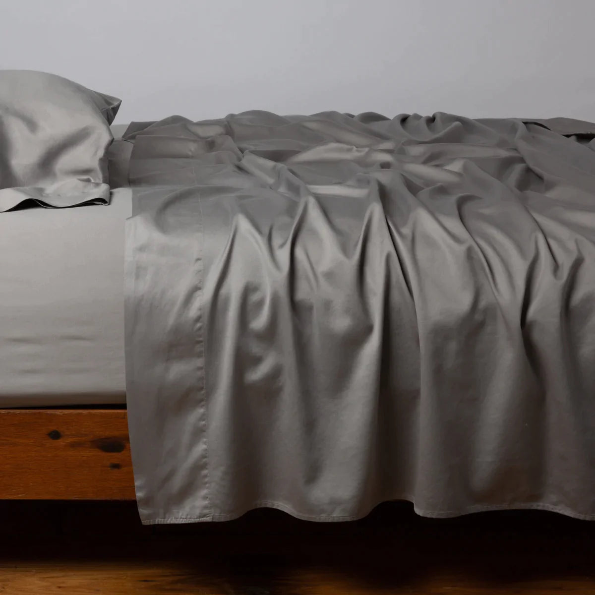 Moonlight: Cotton sateen flat sheet, shown with matching fitted sheet and sleeping pillow - side view.