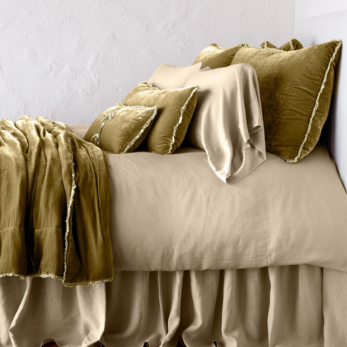 Honeycomb: Silk velvet throw blanket with petite ruffle, draped across a monochromatic bed - side view.