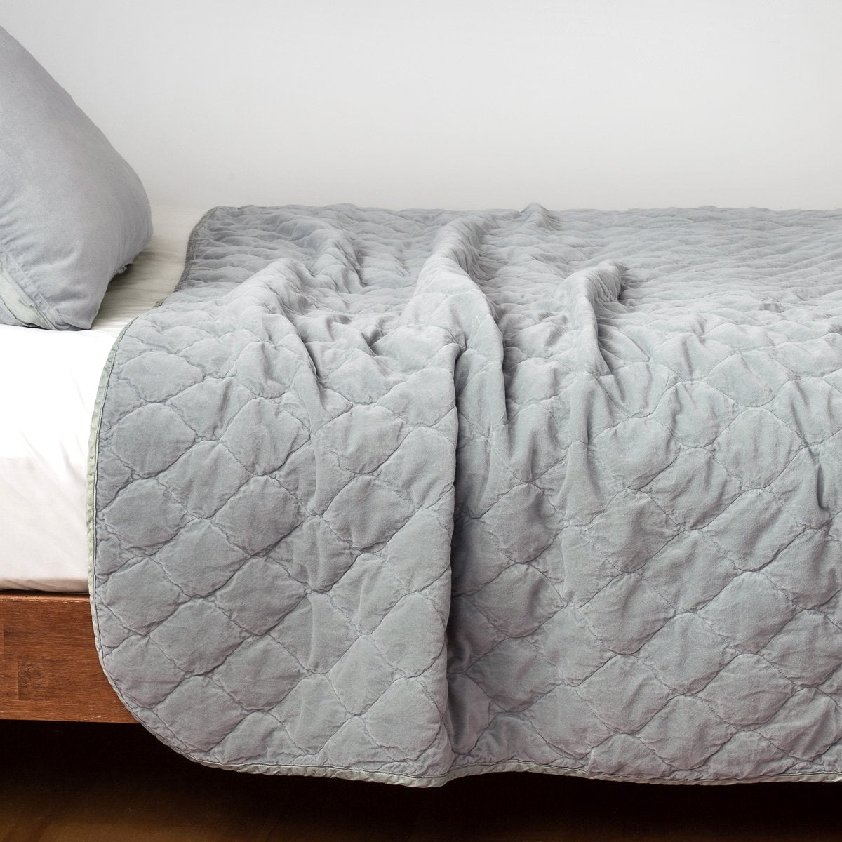Mineral: Quilted cotton velvet coverlet draped over a white fitted sheet - side view.