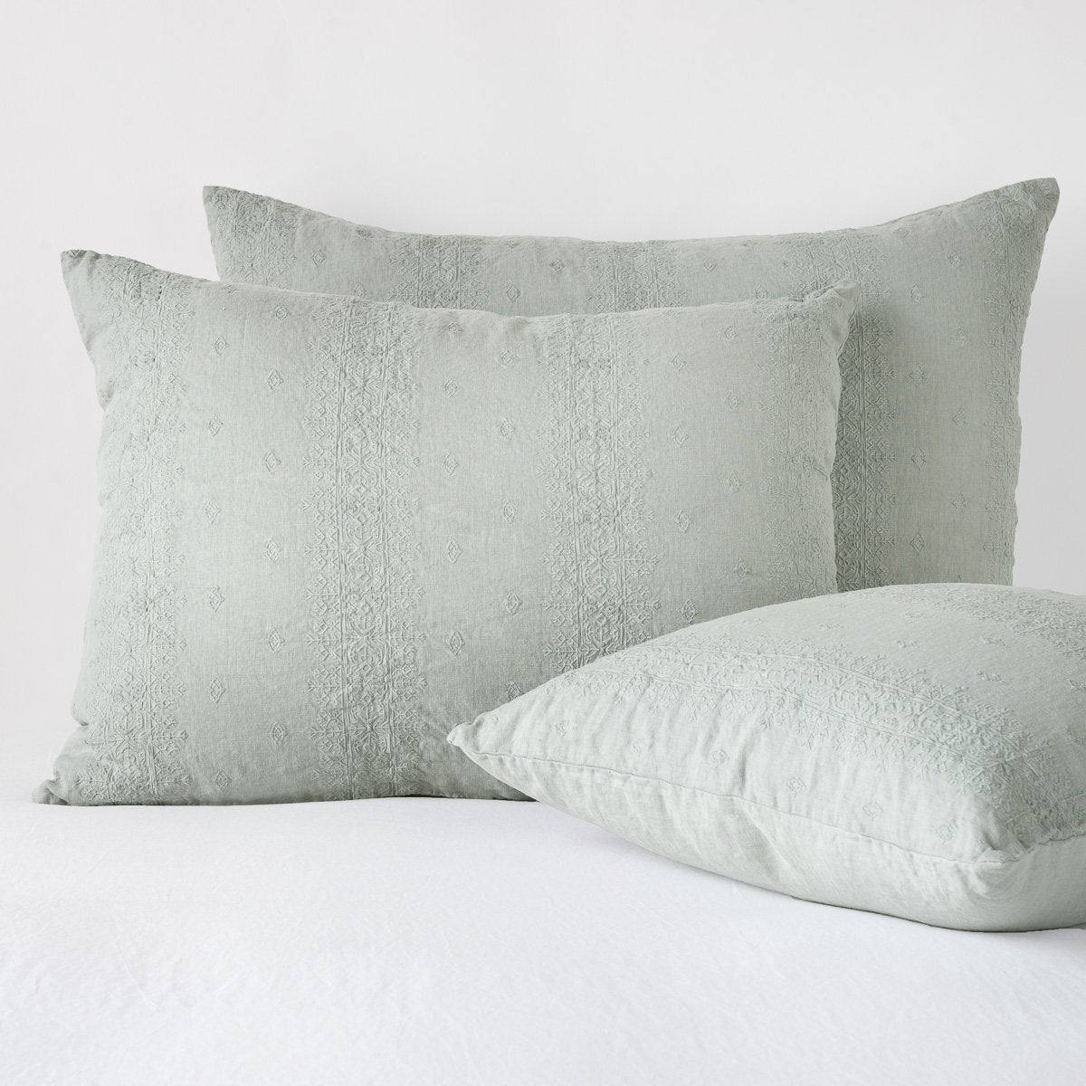 [allvariants]: Ines shams in eucalyptus - two leaning upright and one laying flat at an angle in the foreground, against a blank background.