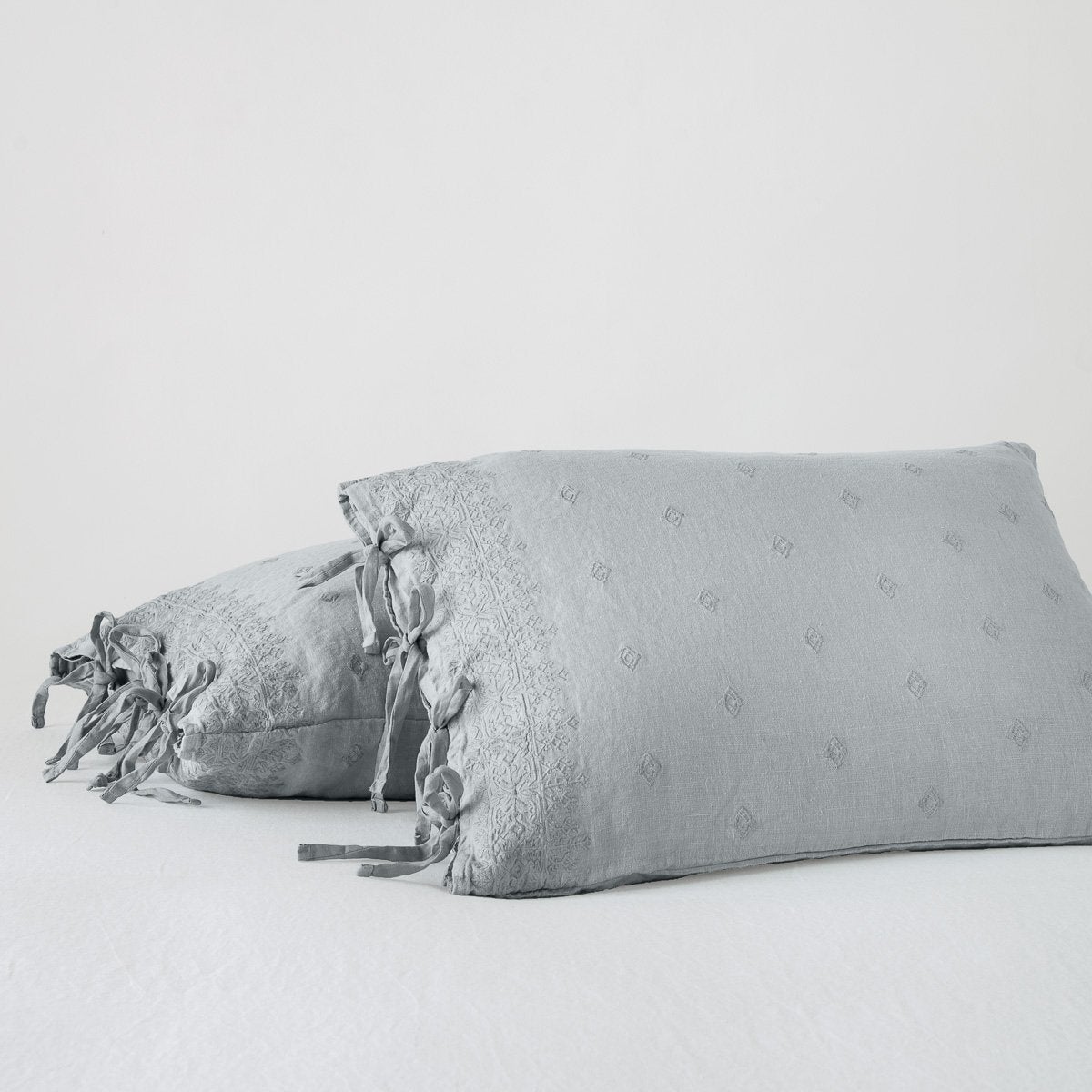 Mineral: standard sham leaning against a king sham, on a white background and at a slight angle to showcase the linen side-tie closure.