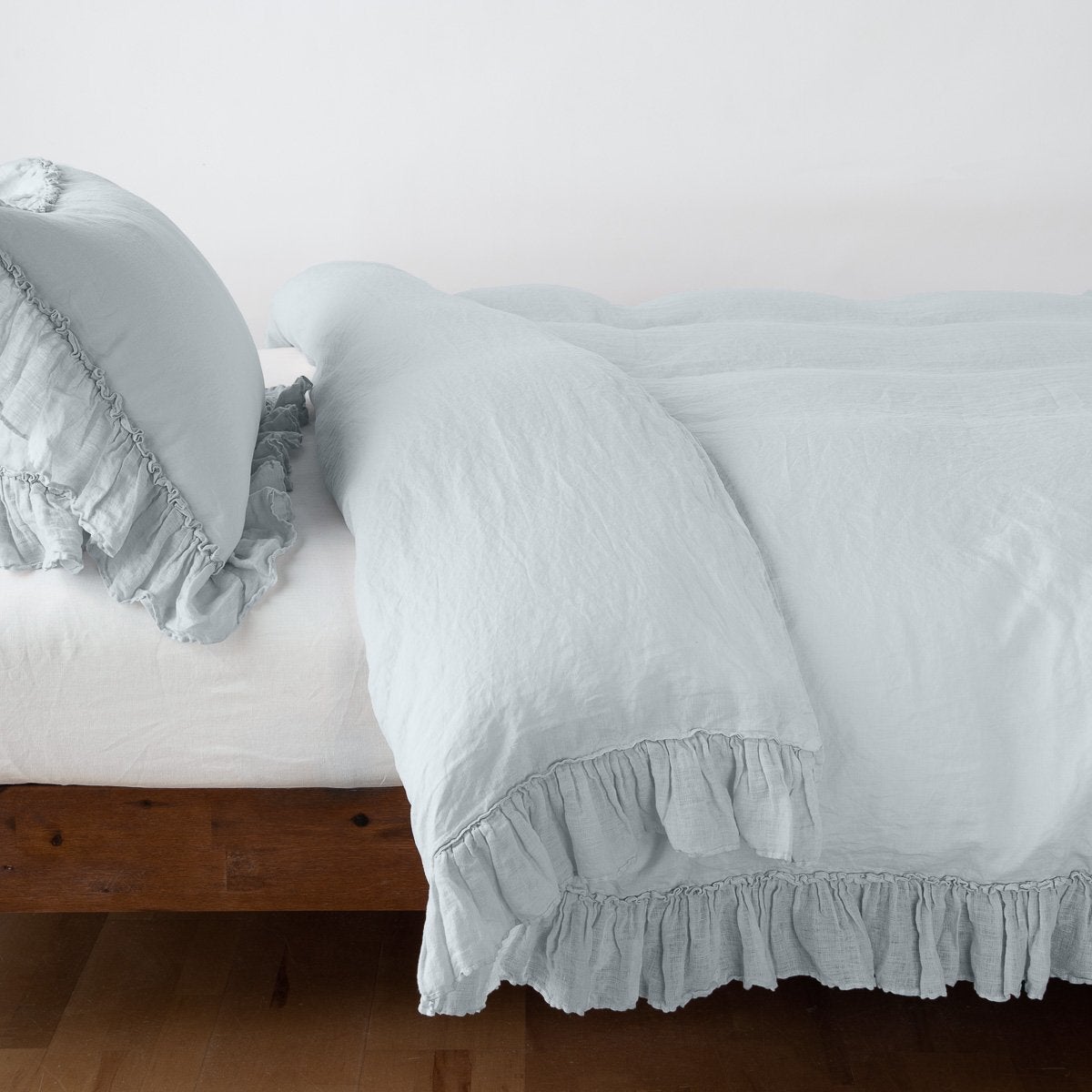 Cloud: duvet cover folded back over a white fitted sheet, shown with matching sham against a plain background - side view.