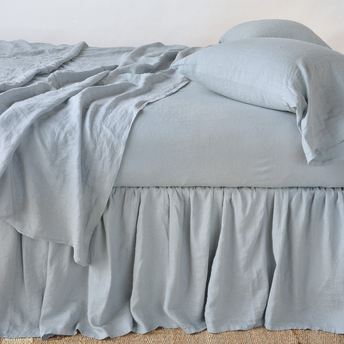 Mineral: bed skirt with matching rumpled sheets and sleeping pillows - side view.