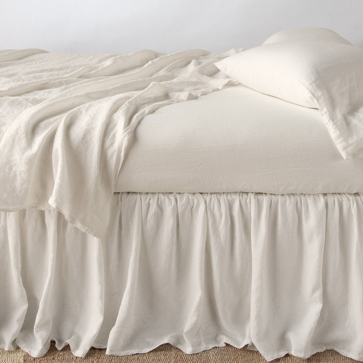 Parchment: bed skirt with matching rumpled sheets and sleeping pillows - side view.