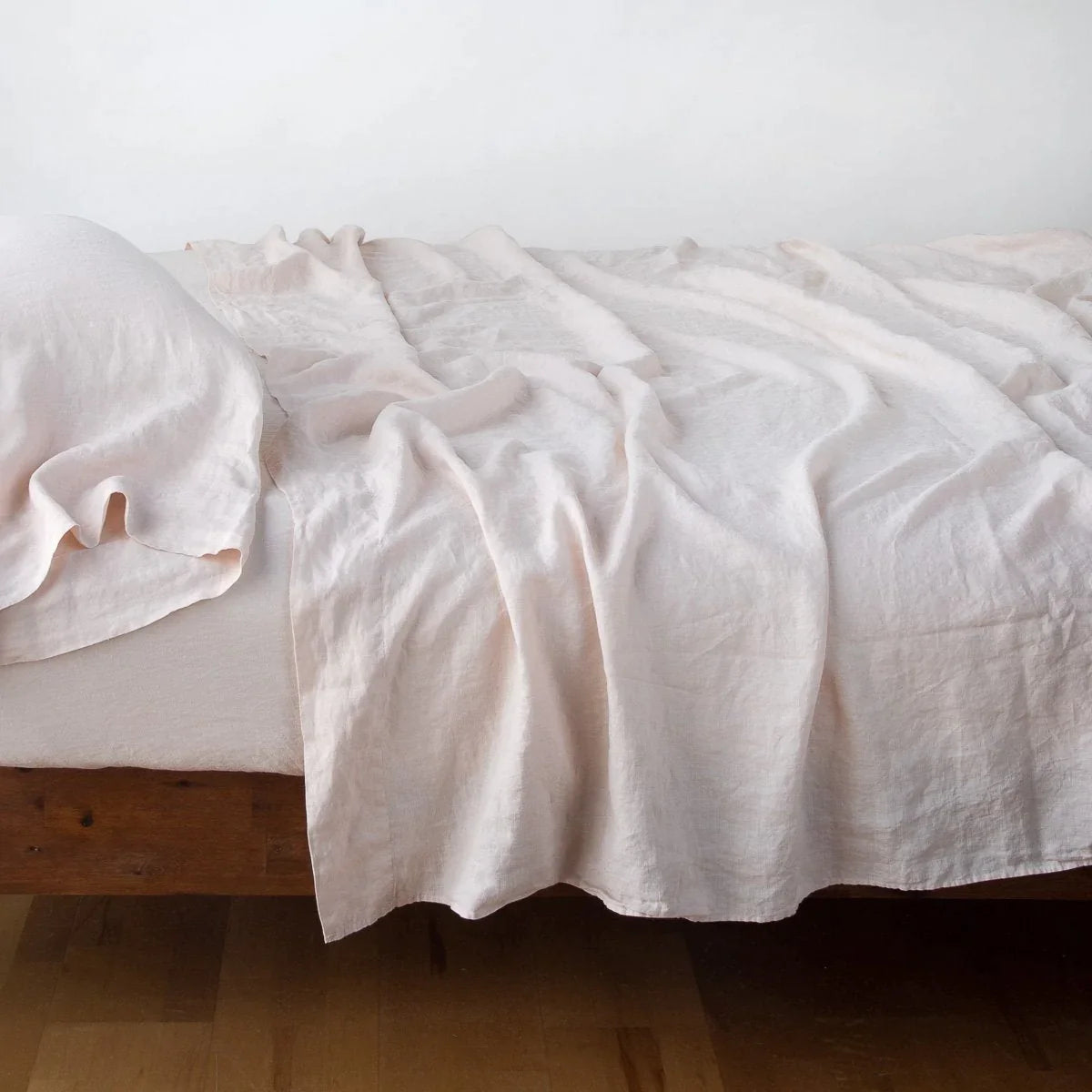 Pearl: fitted sheet with matching rumpled flat sheet and sleeping pillow - side view.