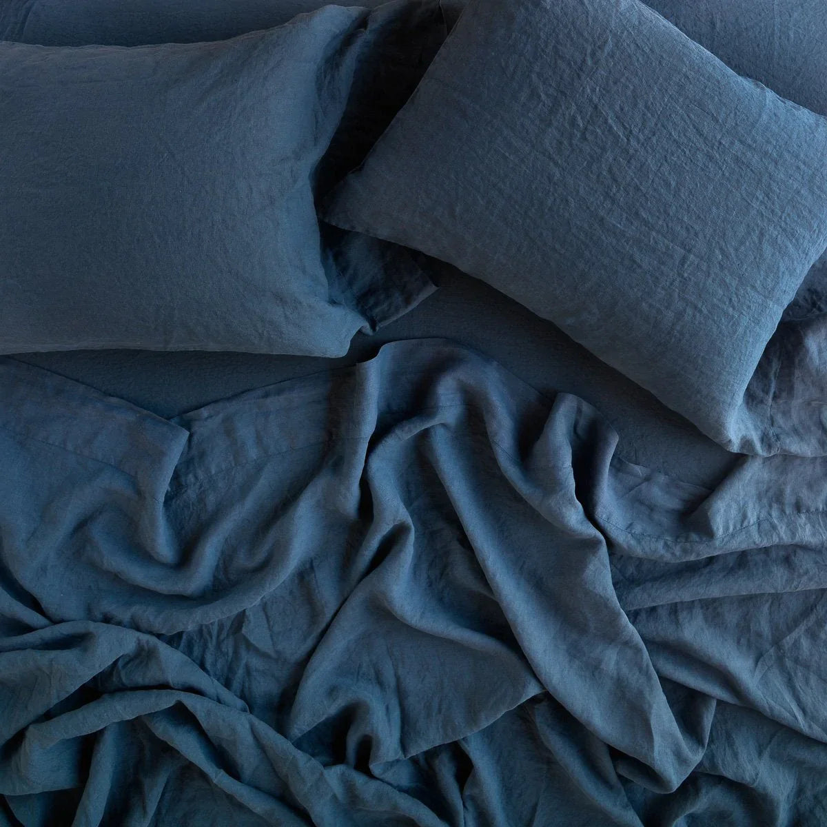Midnight: Rumpled sheeting with matching sleeping pillows - overhead view.