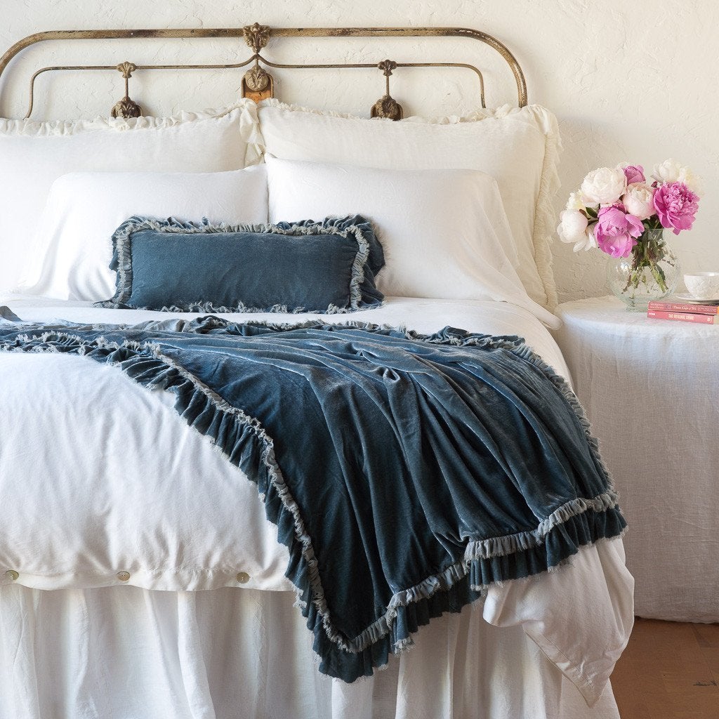 Mineral: throw blanket draped over the end of a white bed, shown with matching accent pillow - end of bed view.