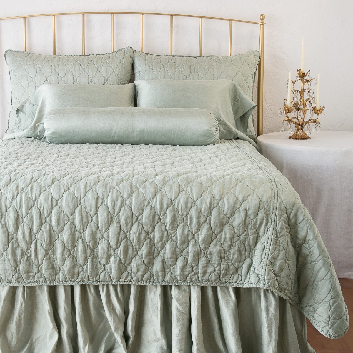 Eucalyptus: coverlet on a shining, monochromatic bed with matching shams - end of bed view.