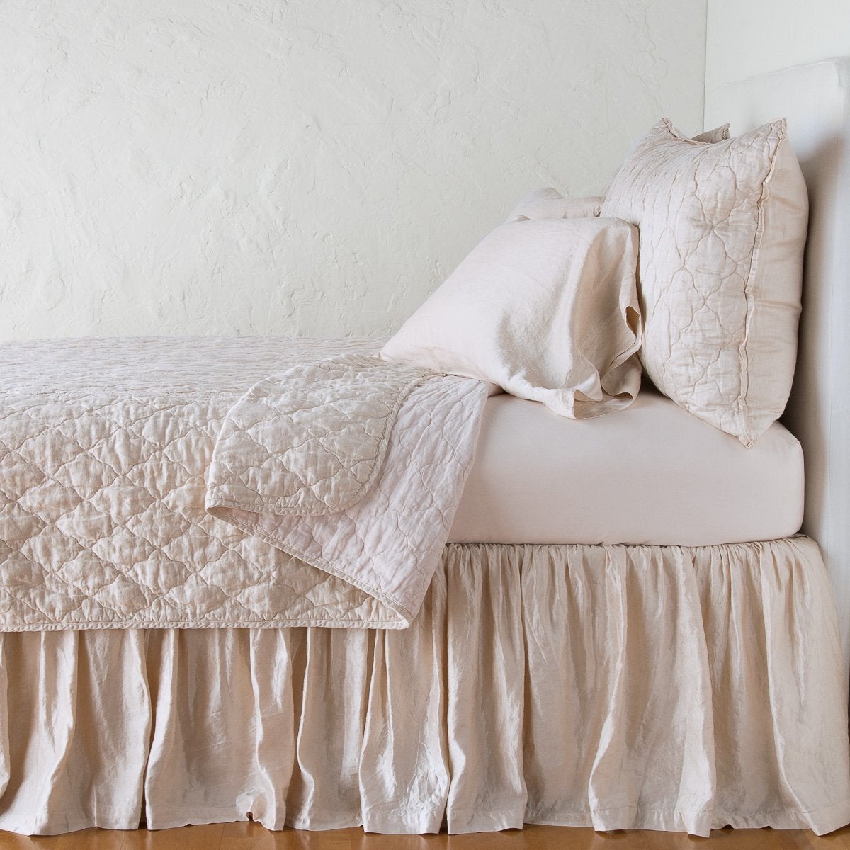 Pearl: coverlet neatly folded back to reveal linen reverse, on a monochromatic bed - side view.