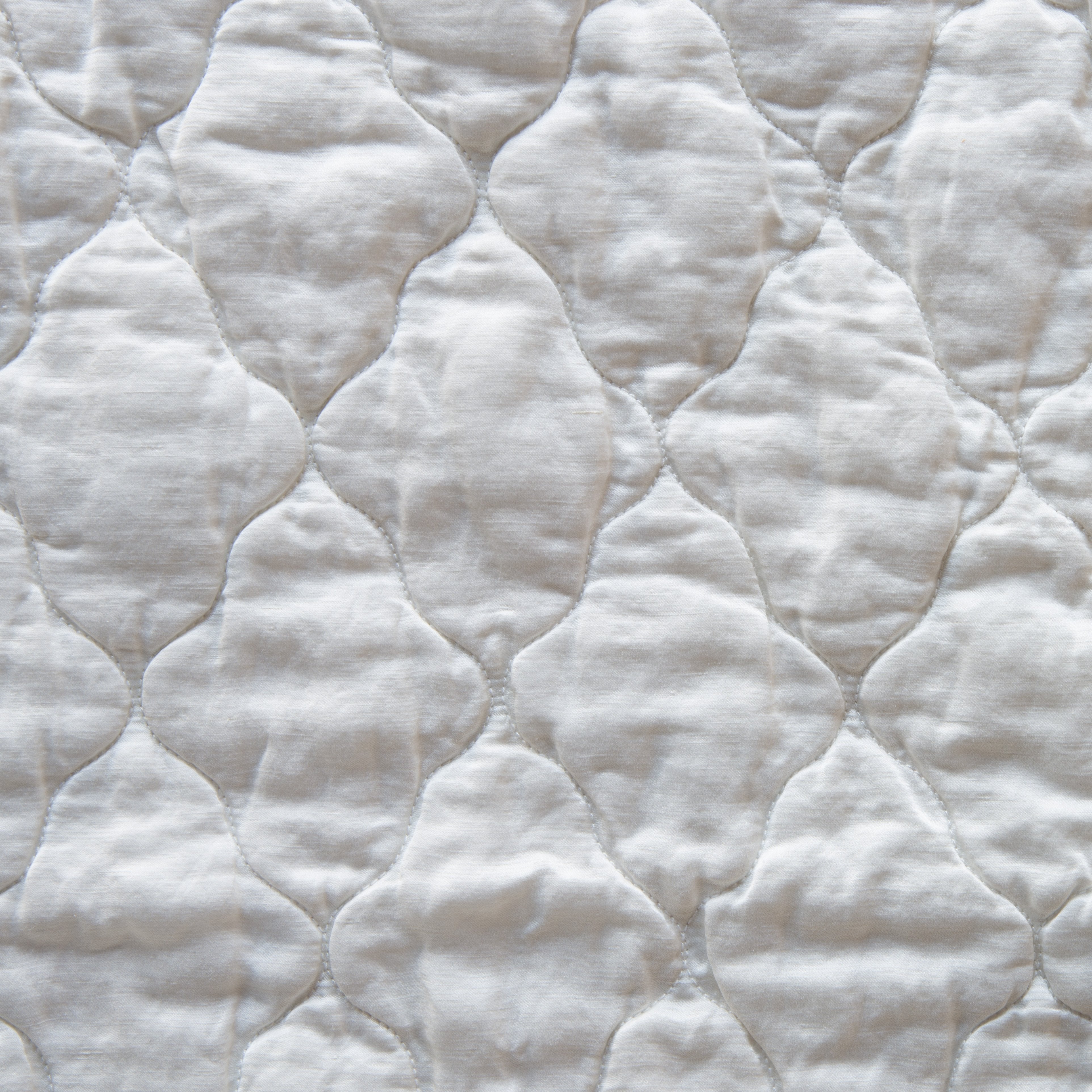 Winter White: Close-up of Luna silk charmeuse quilting in winter white, softer and warmer in tone than classic white.
