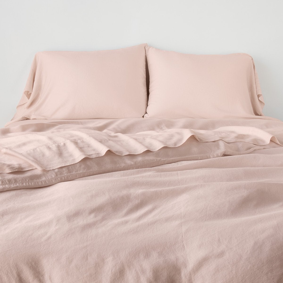 Rouge: duvet cover with matching sleeping pillows and sheeting against a white wall - end of bed view.