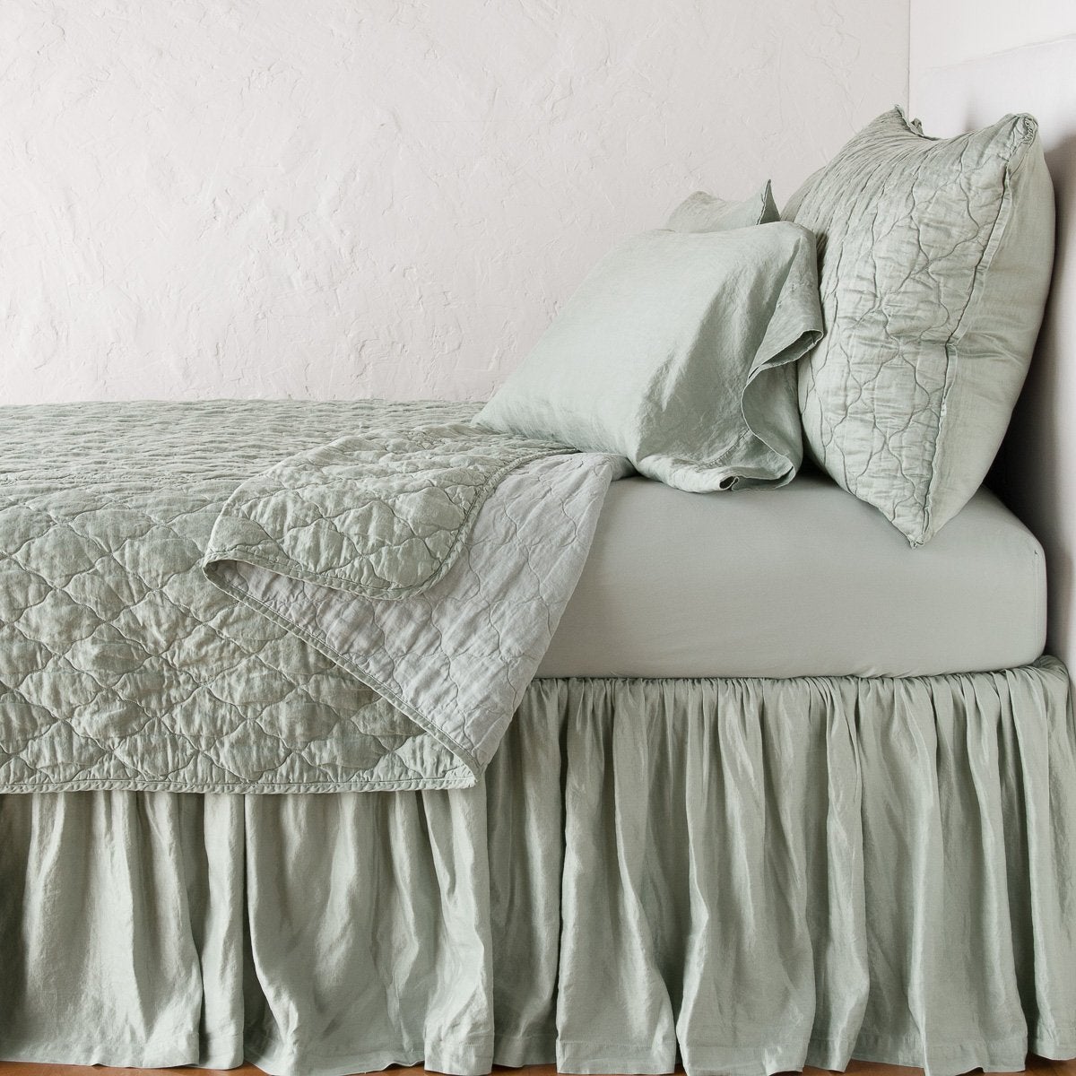 Eucalyptus: sleeping pillows on a monochromatic charmeuse bed - side view.