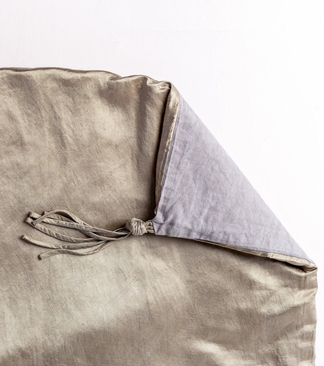 : Close up of Taline in moonlight, with a corner turned back to showcase the midweight linen back and corner tassel - overhead view.