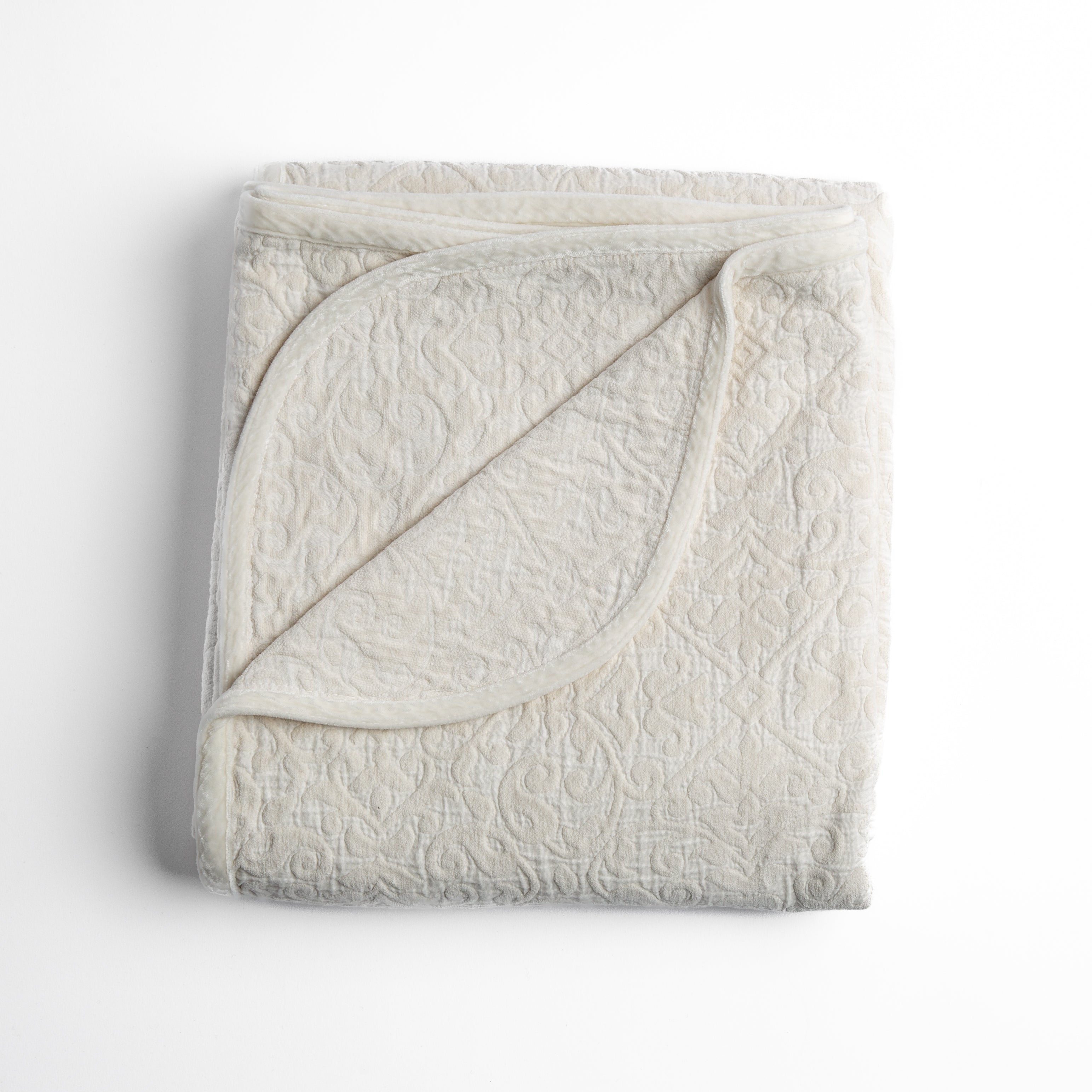 Winter White: Folded cotton chenille jacquard blanket with corner folded back — overhead on a plain white background. 